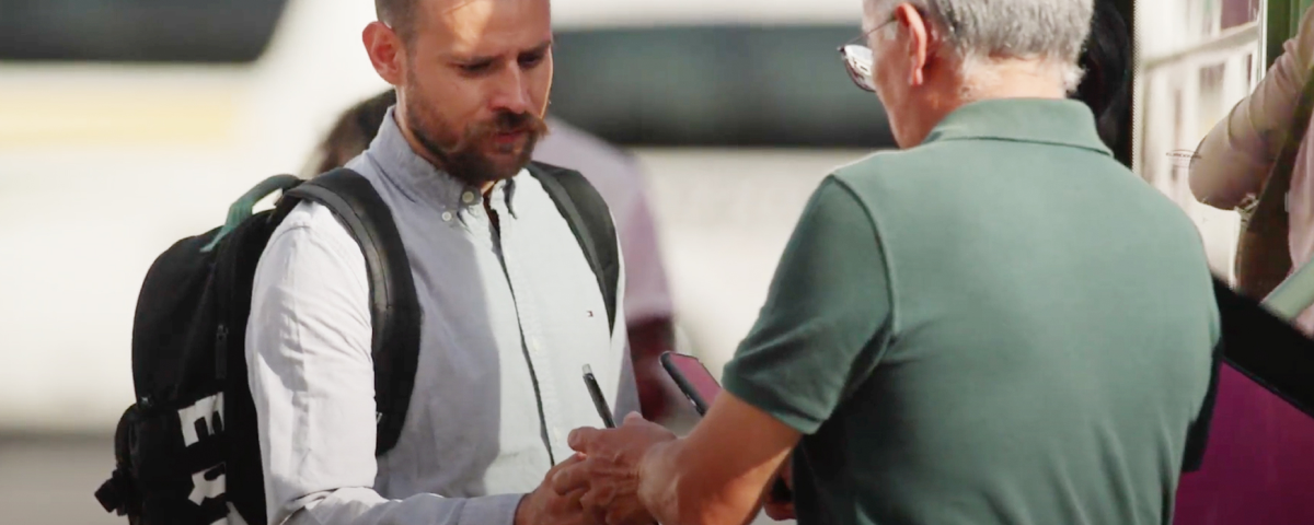 Dos hombres estrechando la mano de manera amistosa al aire libre.