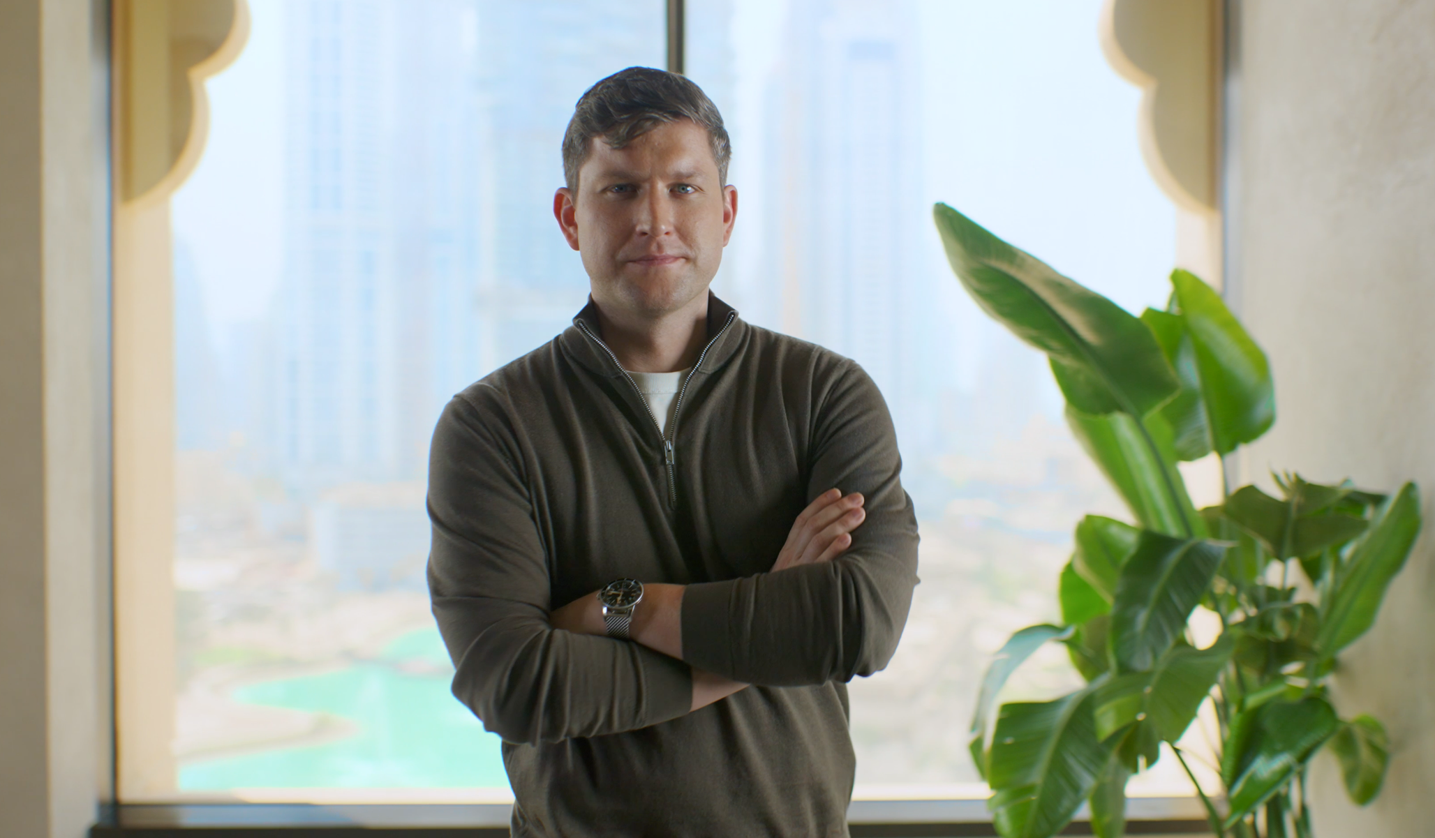 Adyen team member in the office with a large plant and city view in the background