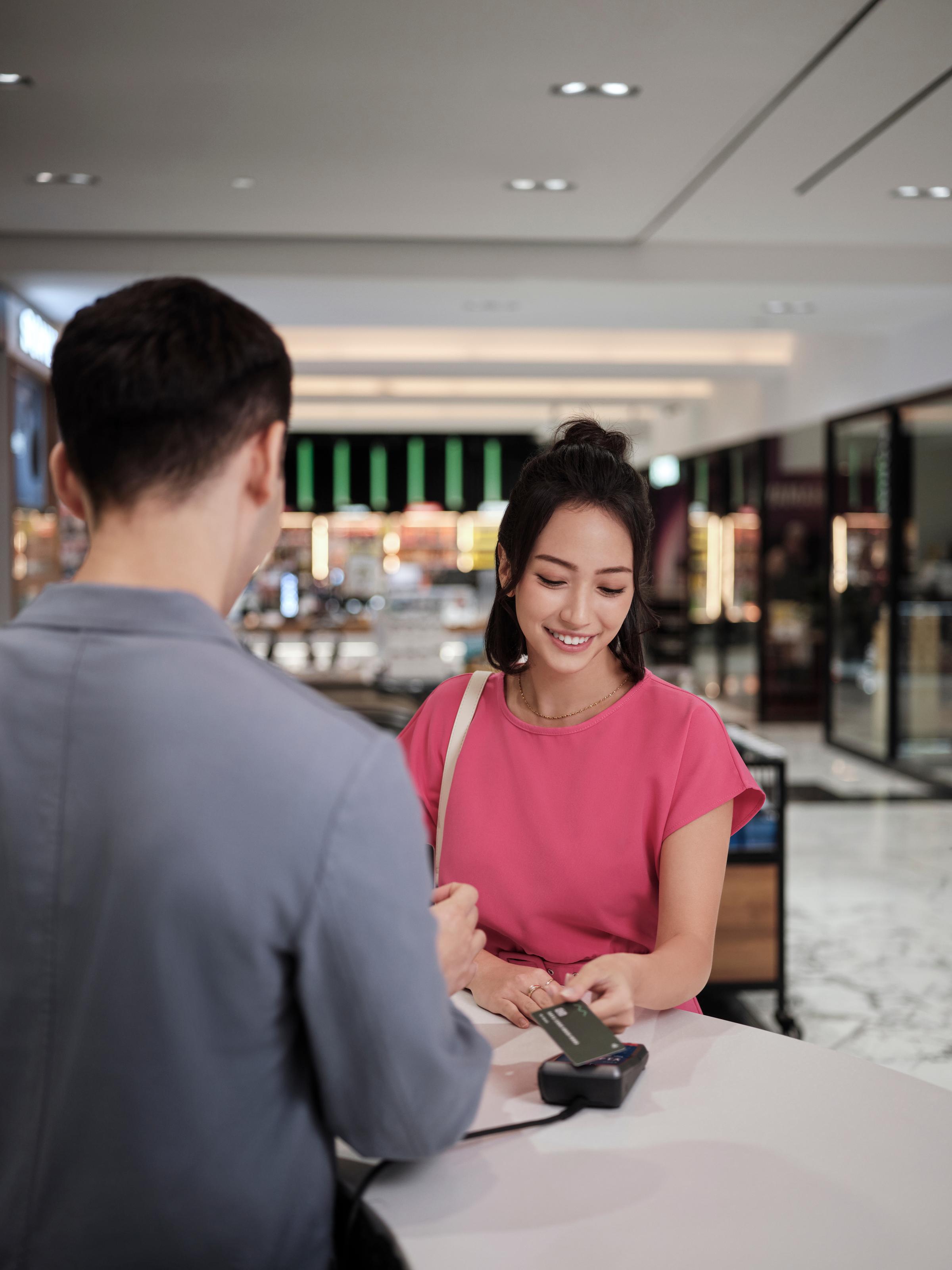 Asian woman paying with credit card