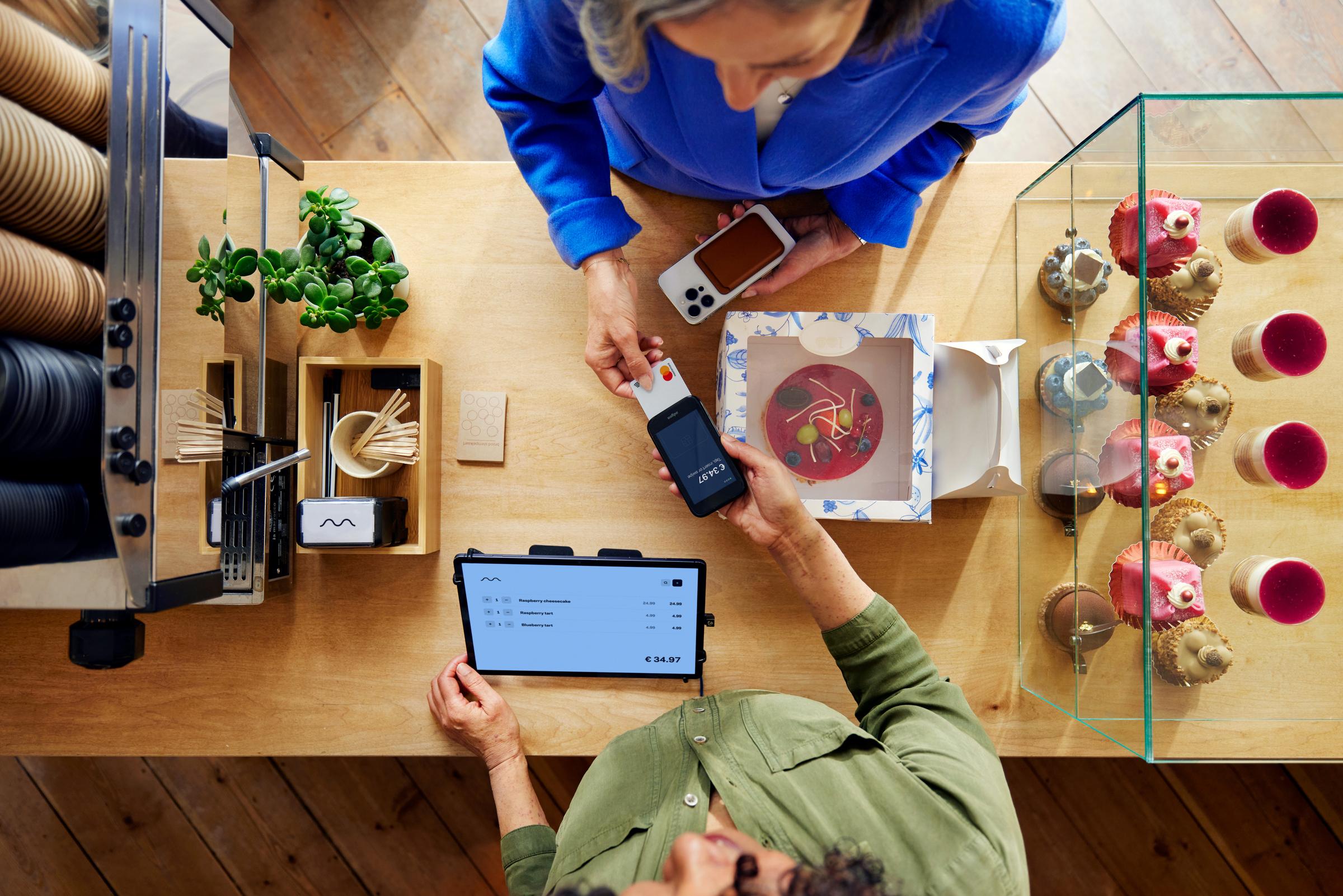 A customer in a coffee shop paying by card using Adyen's AMS1 terminal through a SaaS platform for food & beverage