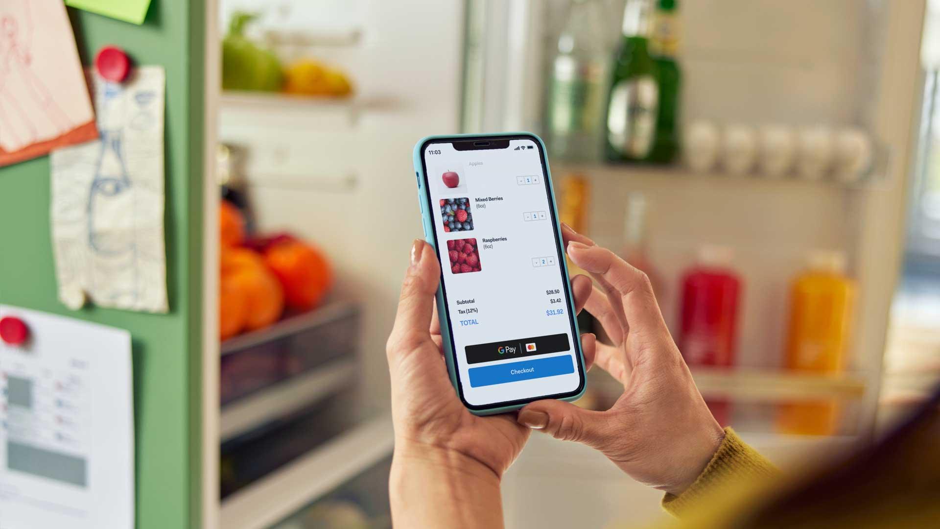 Person holding smartphone showing a shopping cart with Adyen checkout screen.