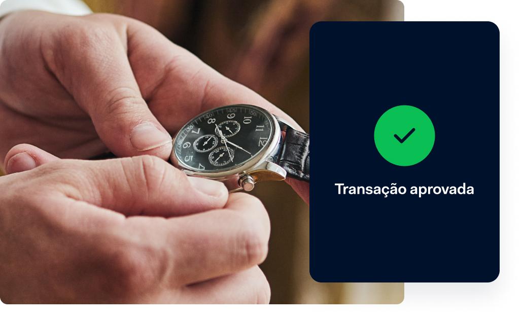 Pessoa ajustando um relógio de pulso com uma notificação de aprovação Adyen na tela