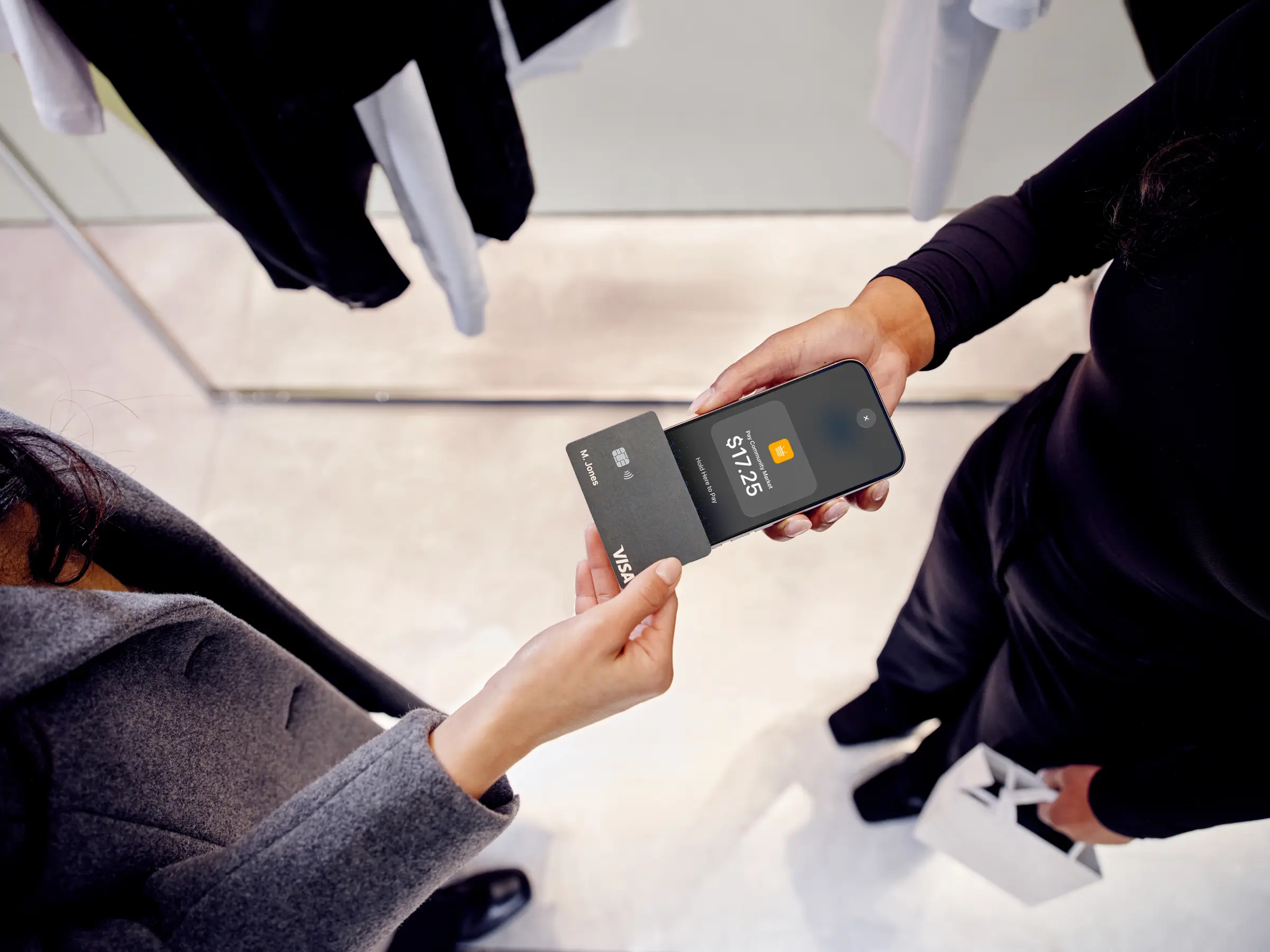 Business professionals using a mobile device for a contactless payment with an Adyen terminal