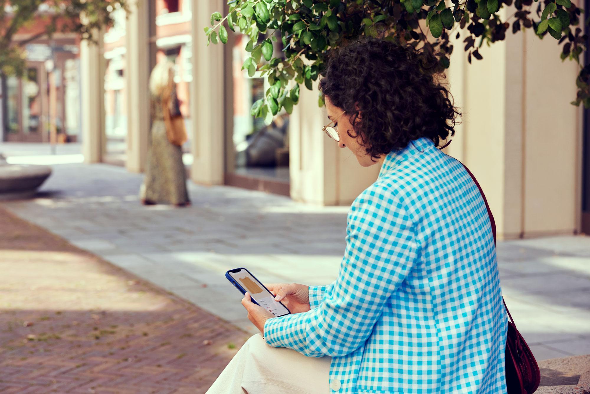 A woman shopping for clothing on her phone.