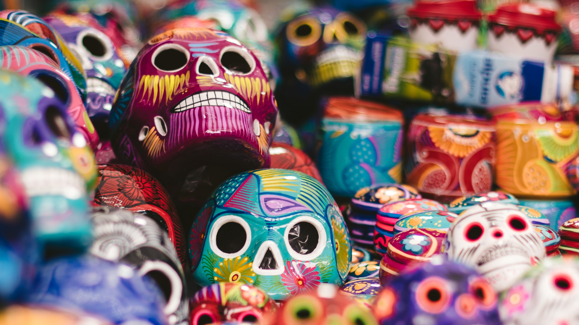 Calaveras del Día de Muertos pintadas a mano de colores en un vibrante escaparate de mercado.