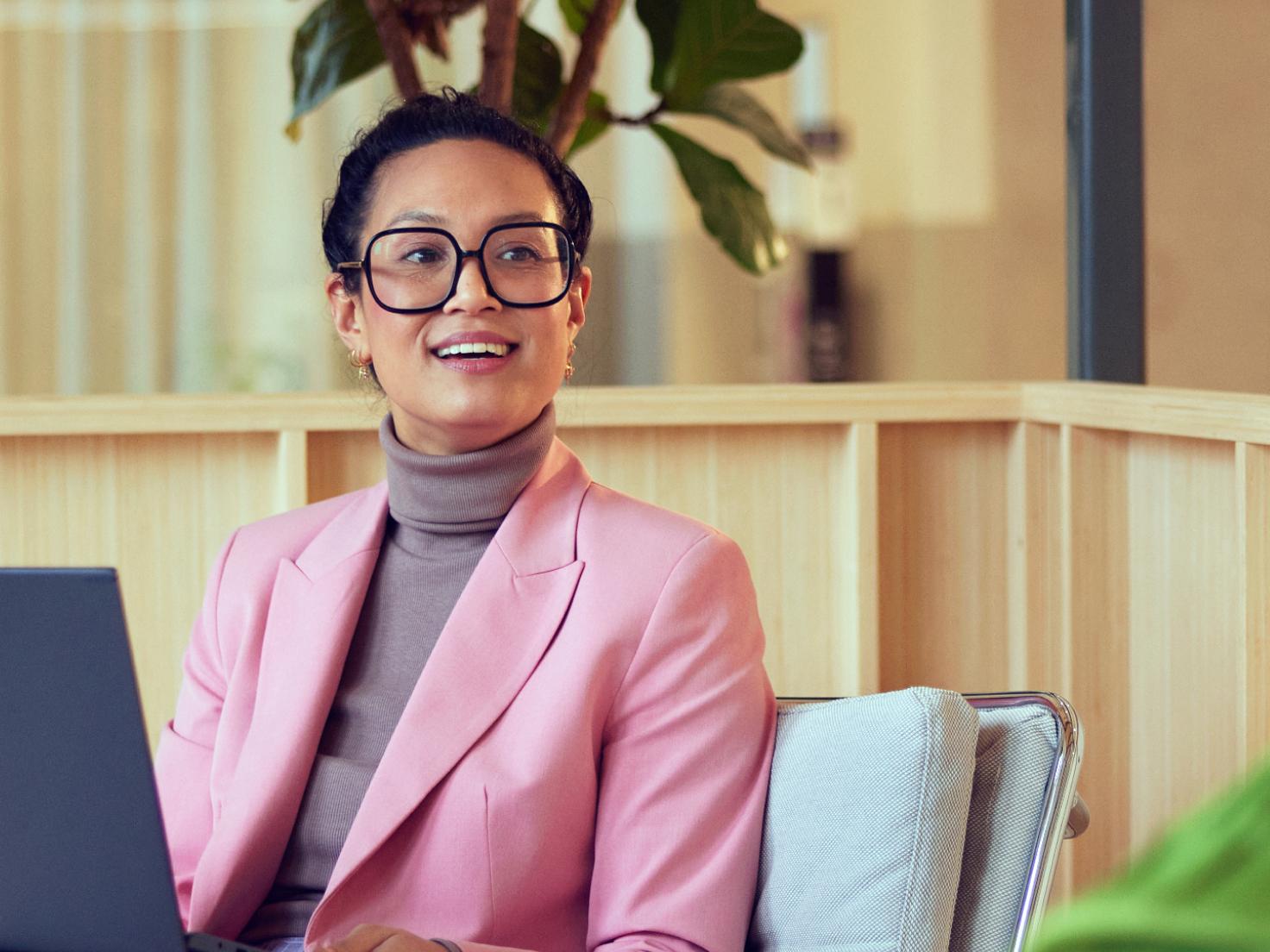 An employee in a cozy Adyen office behind her laptop