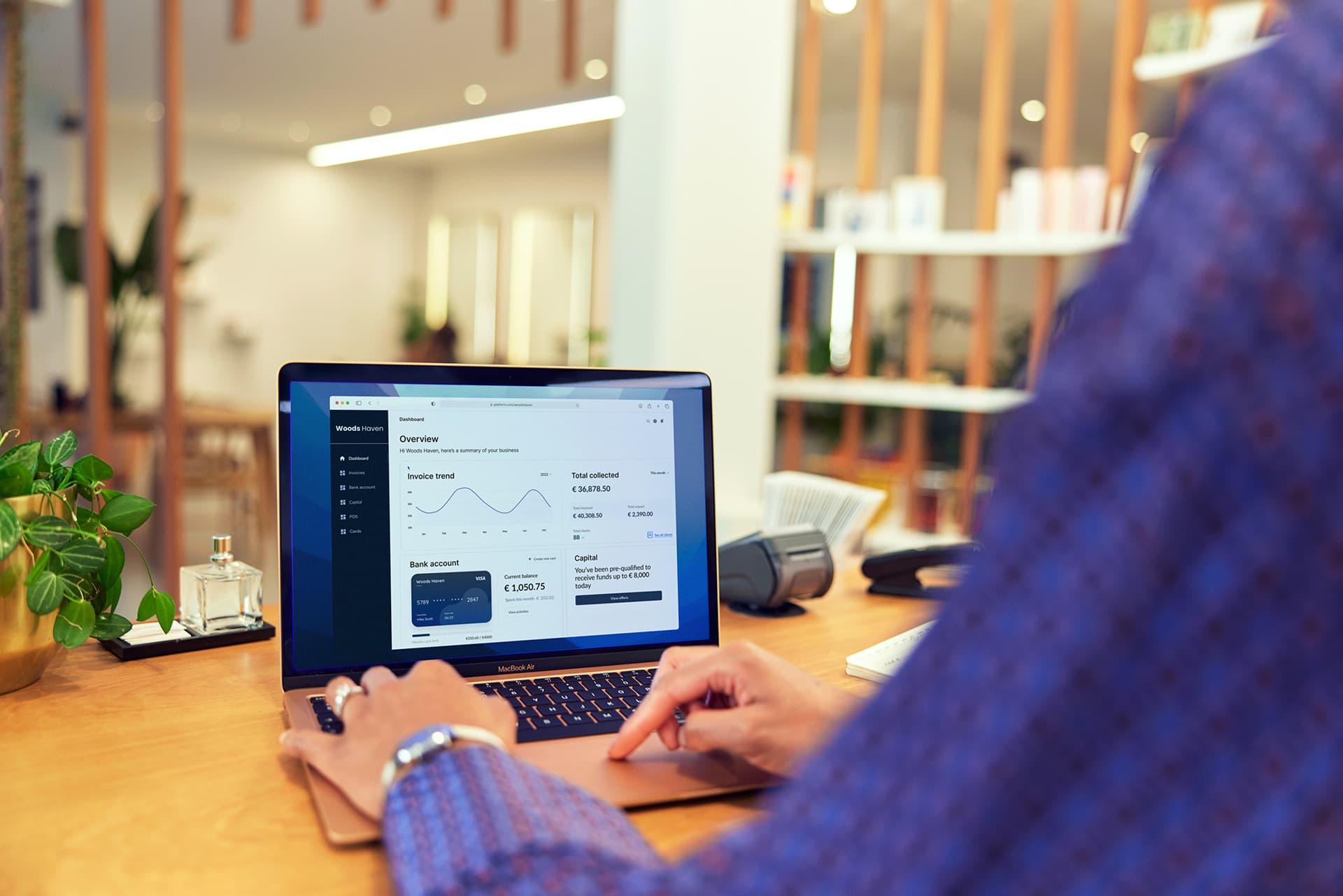Person analyzing financial data on a laptop with Adyen's user interface onscreen.