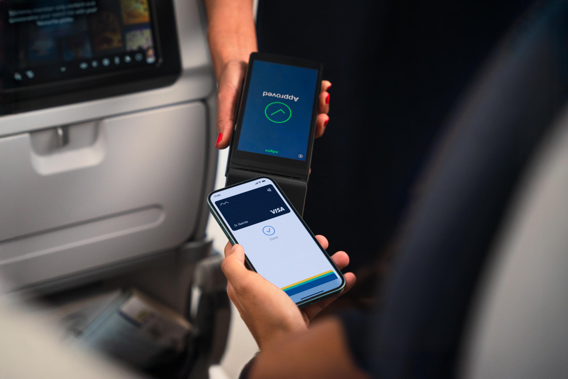 Traveler using a mobile device with an Adyen payment terminal in a transit setting