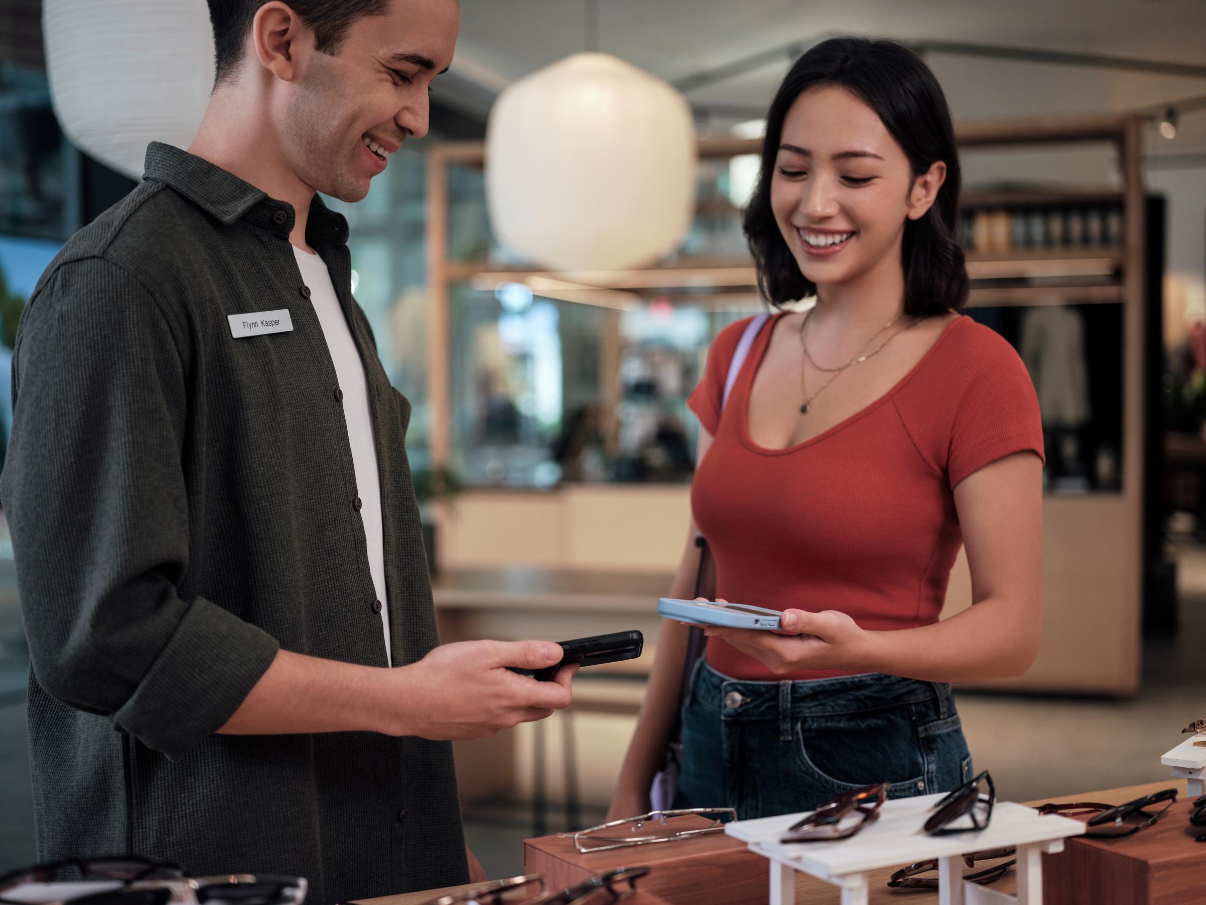 Asian girl paying with mobile phone on AMS1