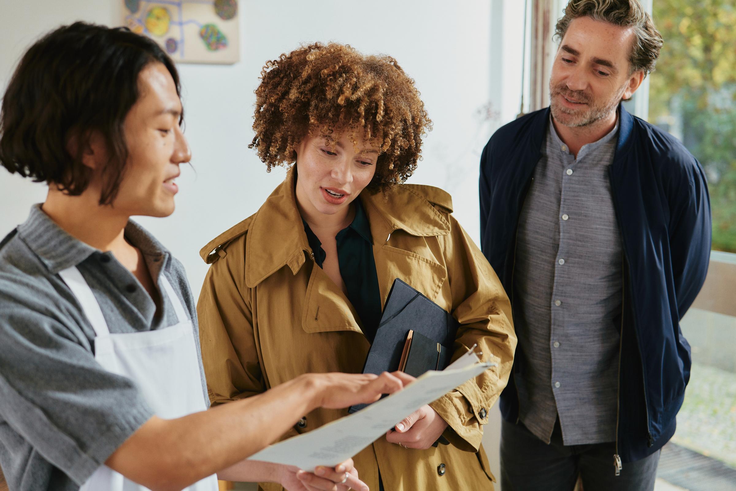 Una pareja en un restaurante discutiendo un menú con un mesero.