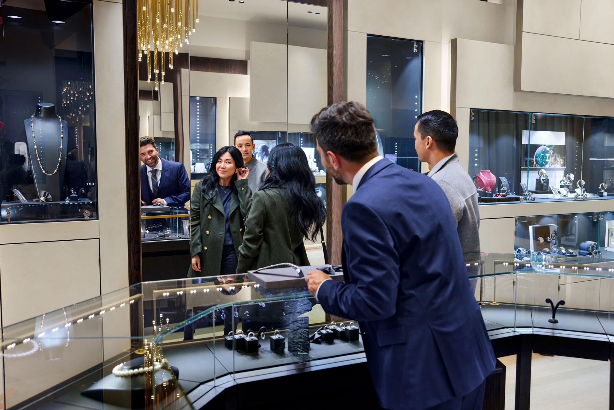 Um casal em uma loja de joias escolhendo brincos e discutindo com um funcionário da loja.