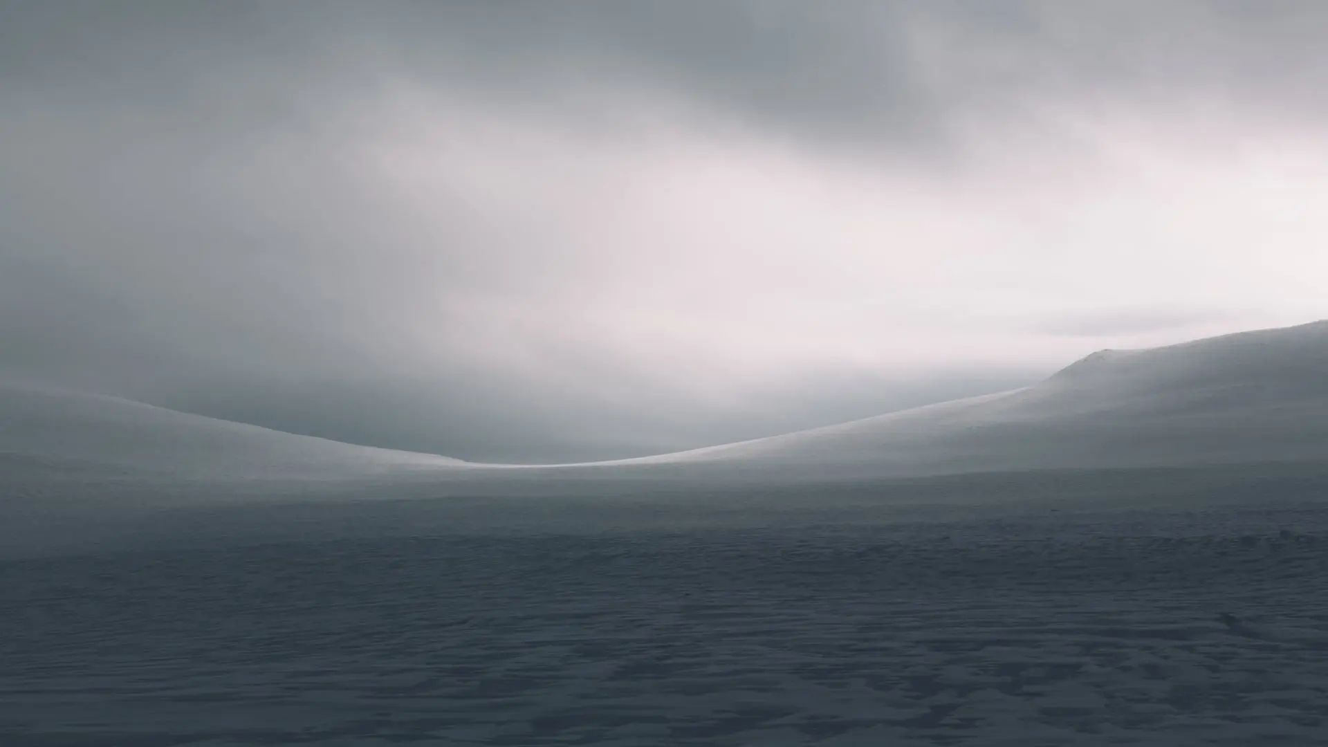 Snow-covered hills under a cloudy sky in Finland.