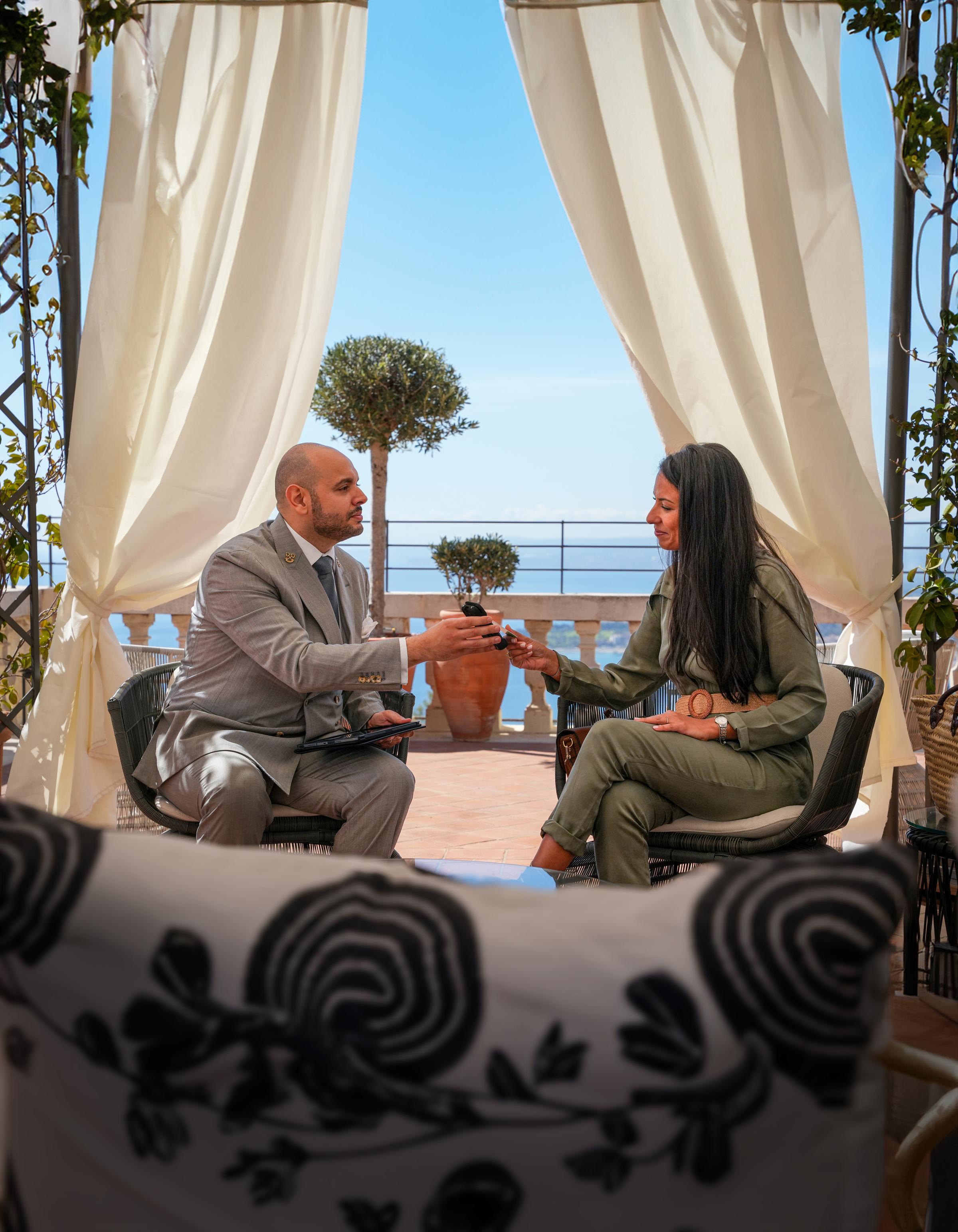A hotel guest paying on a terminal at a Belmond Resort while during check-in