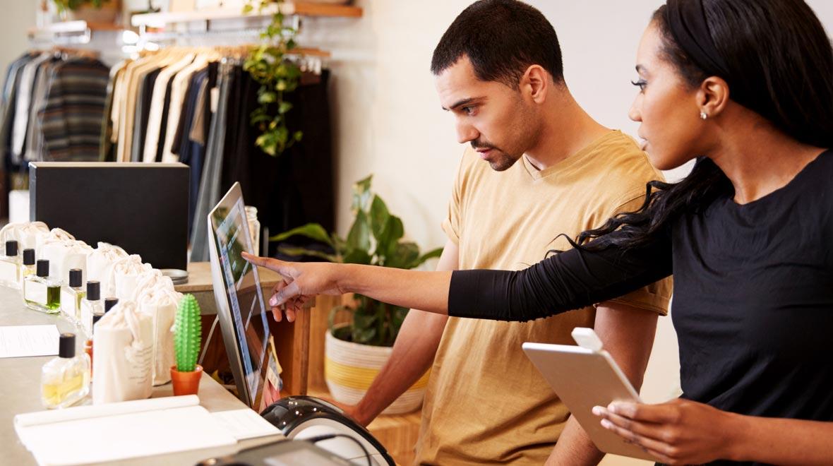 Dos empleados interactúan con un sistema de punto de venta en una tienda minorista.