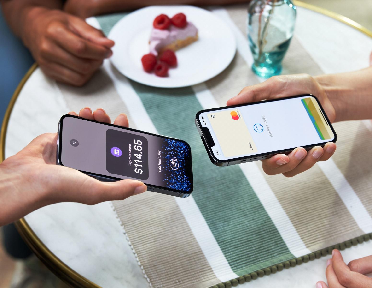 Two people tapping smartphones to process a contactless payment with Adyen app displaying the amount.