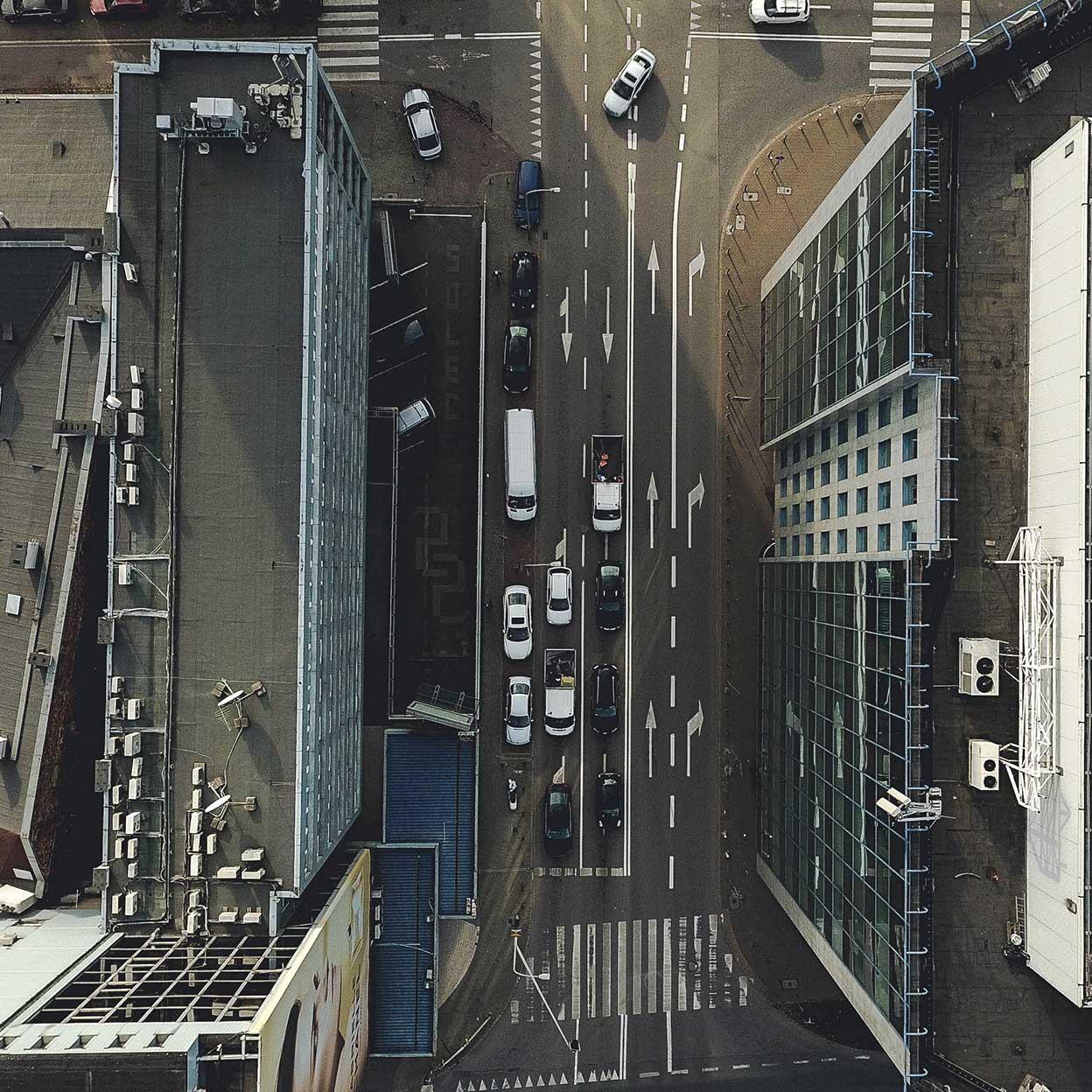 Luftbild av en trafikerad stadsgatukorsning med fordon och tydliga vägmarkeringar