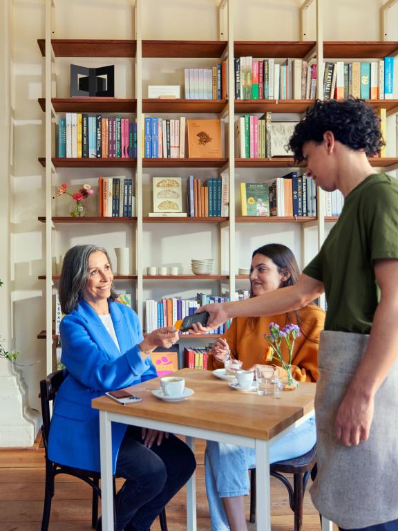 Woman paying at a table in a cafe