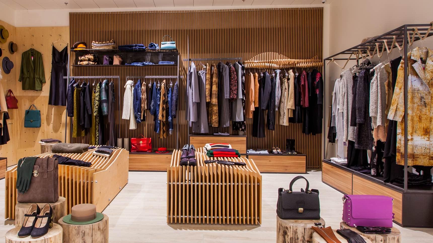 Interior de boutique de ropa moderna con prendas y accesorios ordenados.