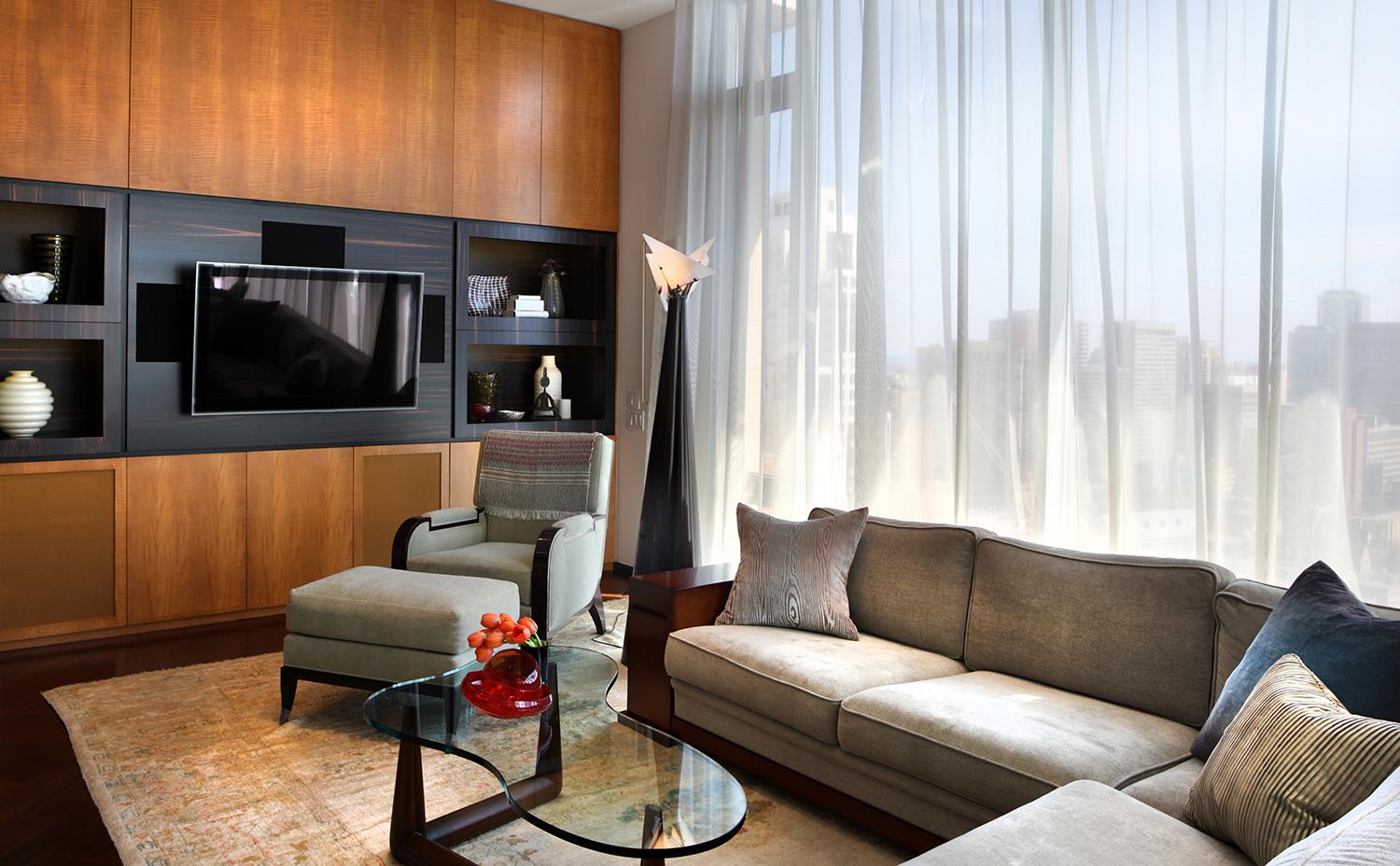 Elegant living room interior with large windows, comfortable furniture, and city view.