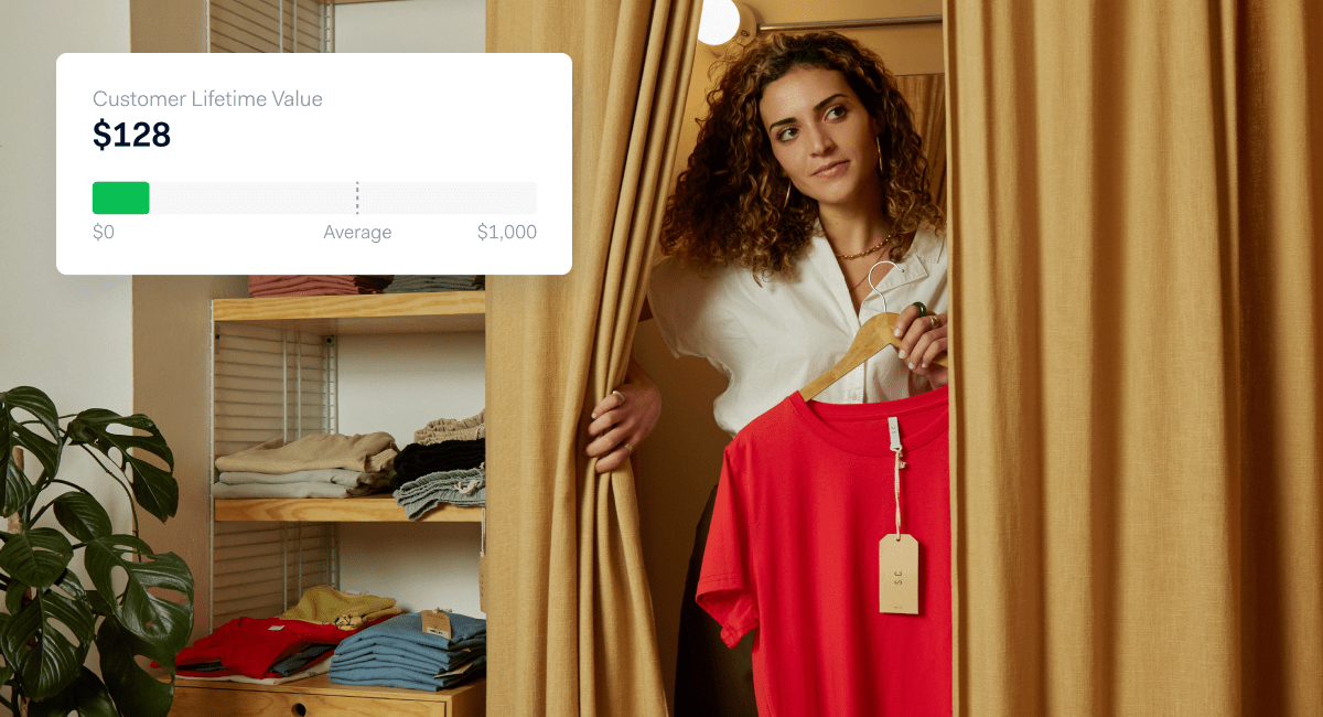 Woman standing in a clothing store behind a curtain with a graphic overlay showing Customer Lifetime Value at $128.
