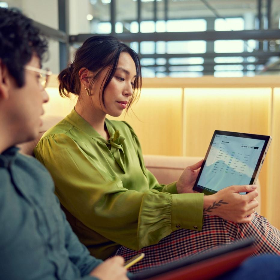 Two people reviewing Adyen payment system on a tablet.