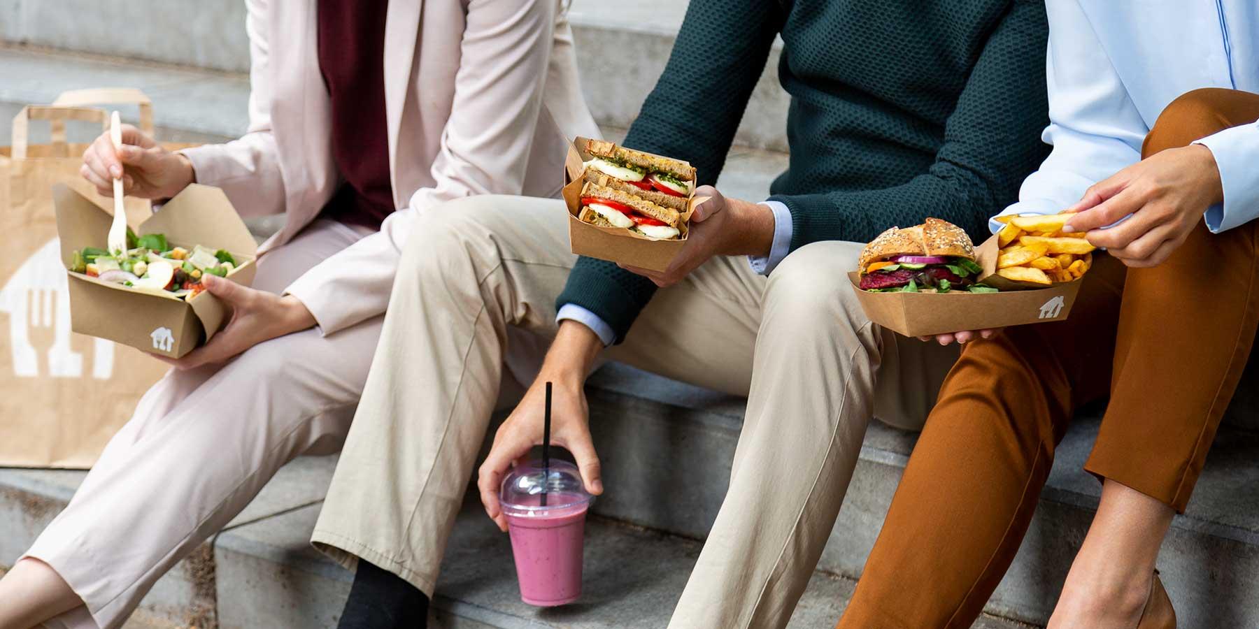 Menschen genießen ihr Mittagessen auf einer Treppe