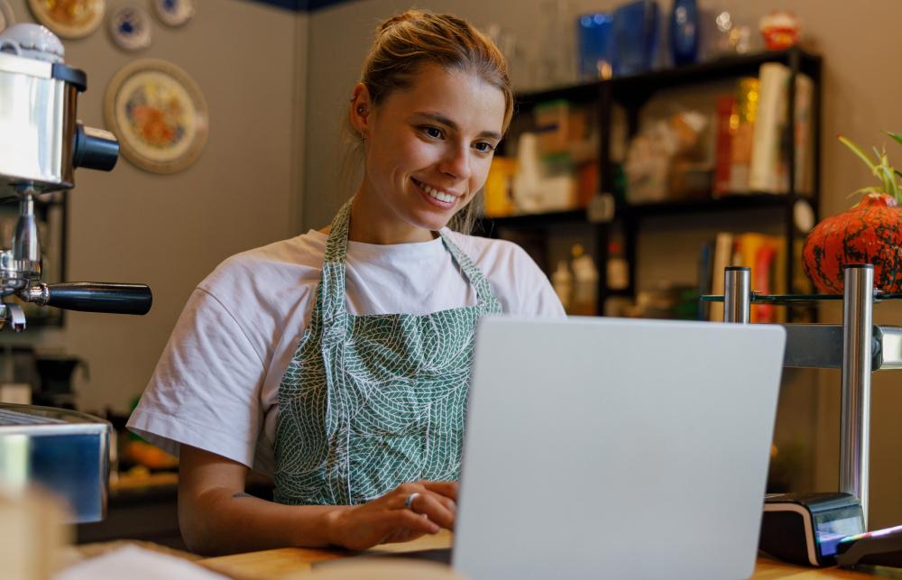 Girl checking laptop in small business bar