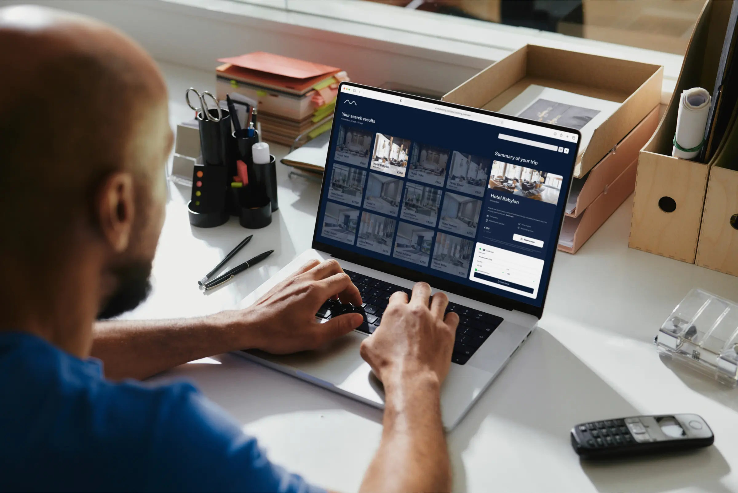 Um homem na frente de um laptop, fazendo uma reserva de hotel usando um sistema de reserva de agência de viagens online (OTA)