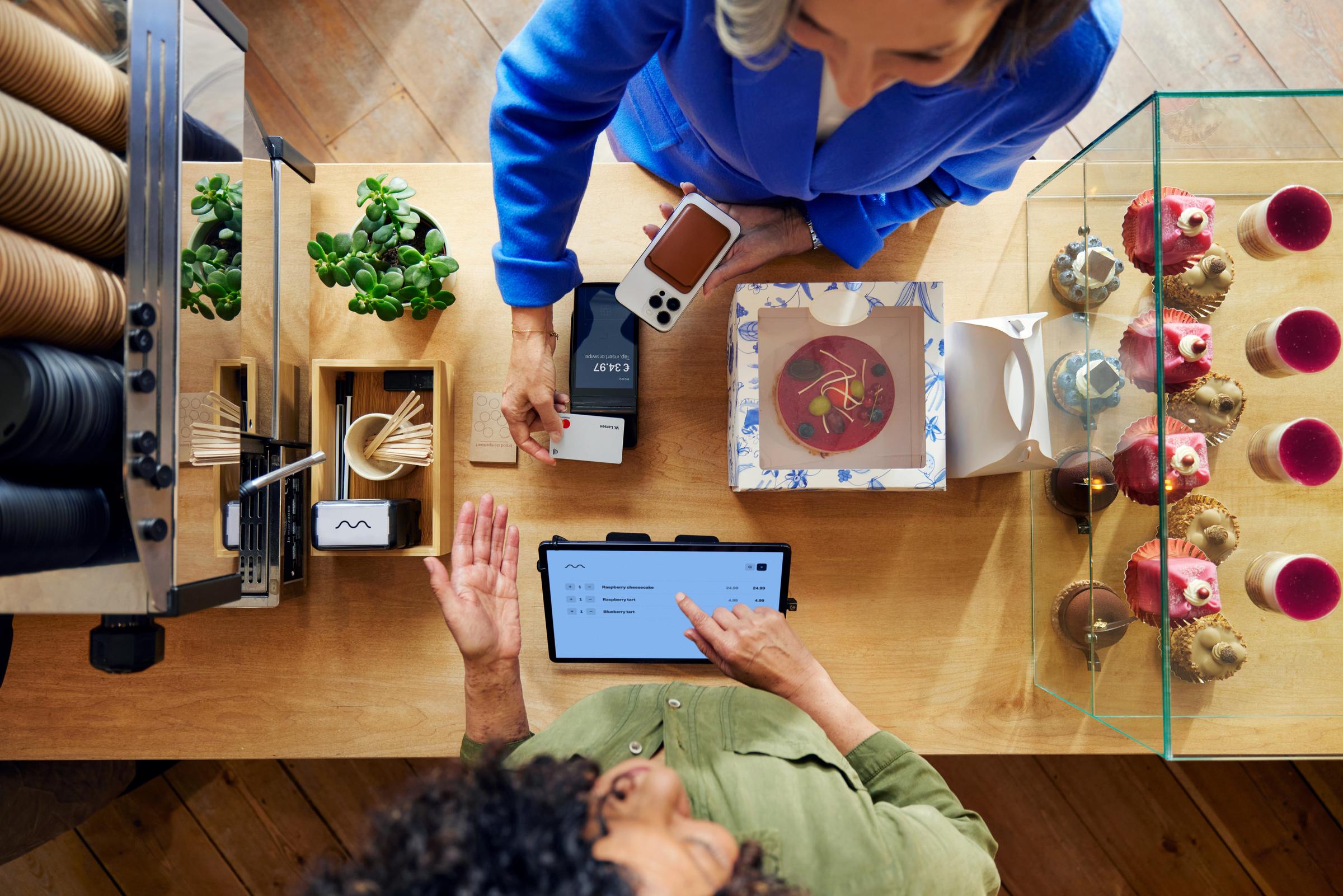 A customer in a coffee shop paying by card using Adyen's S1F2 terminal through a SaaS platform for food & beverage