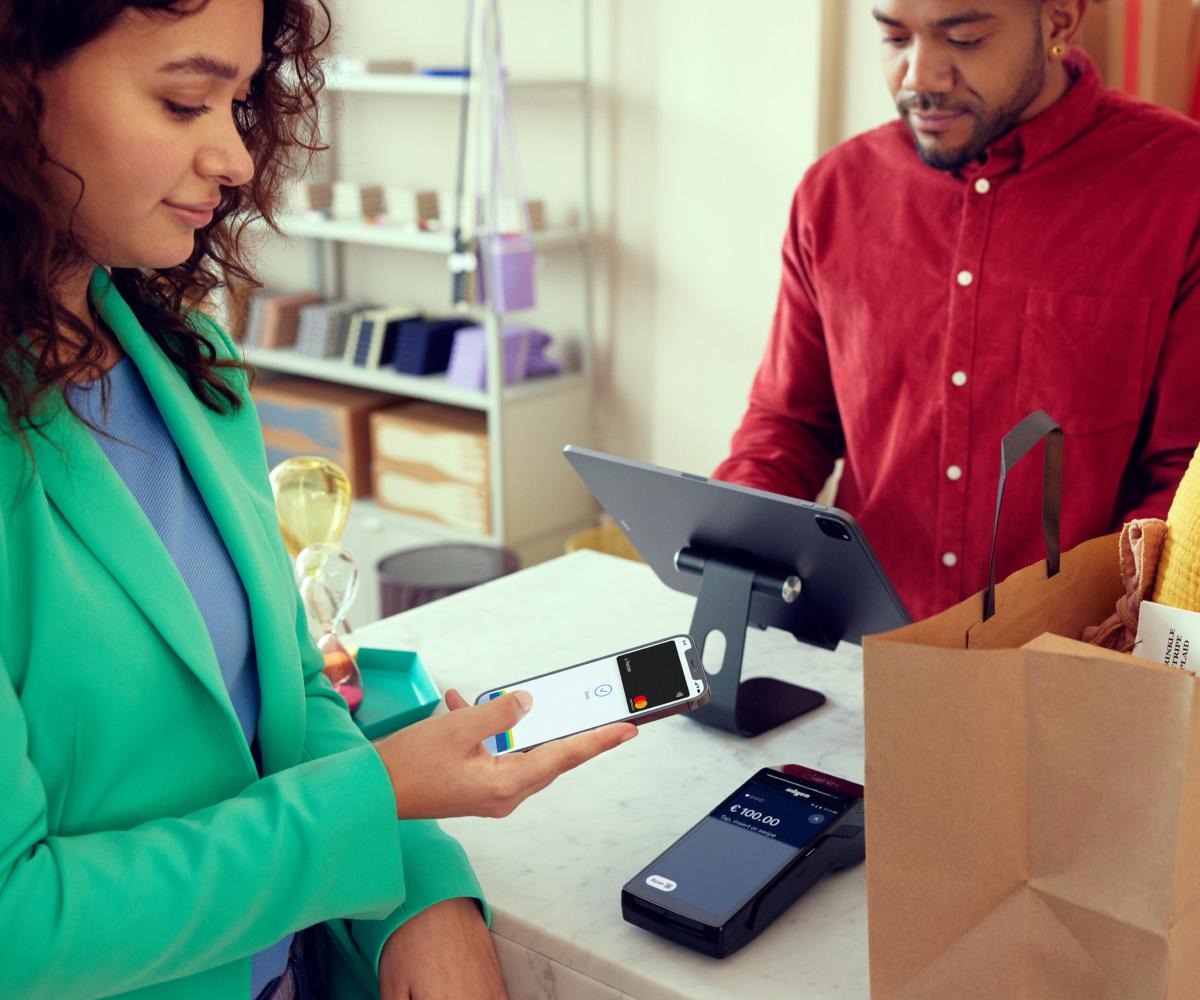 Cliente pagando com uma carteira digital em um smartphone em um terminal de checkout da Adyen em uma loja de artigos para o lar