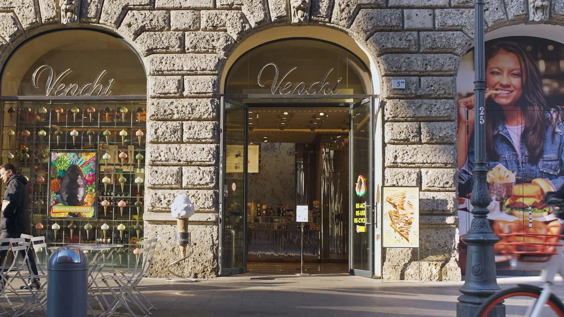 Vista esterna del negozio di cioccolato Venchi con finestre decorate e un passante.