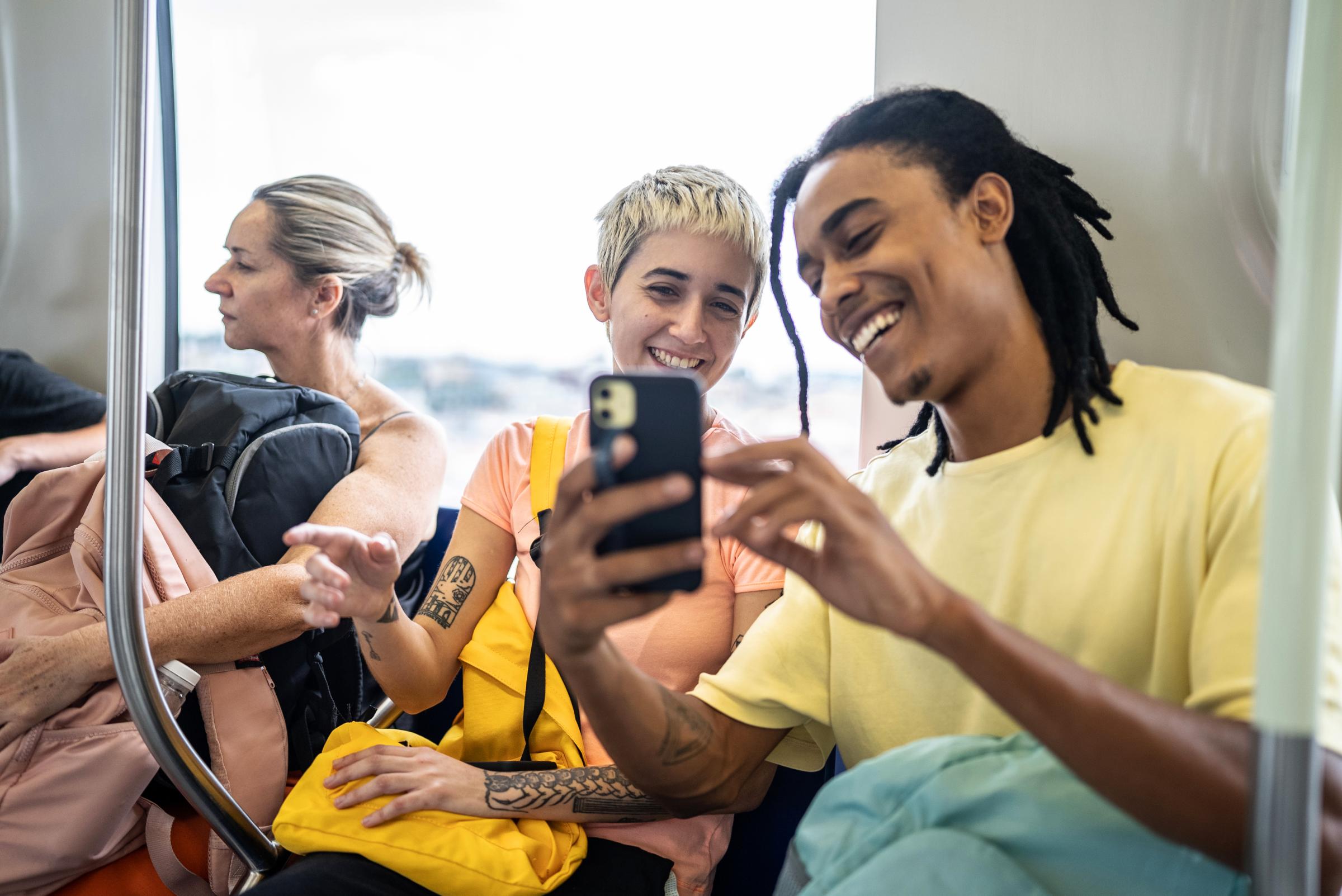 Adyen team members using a payment terminal on a subway during travel.