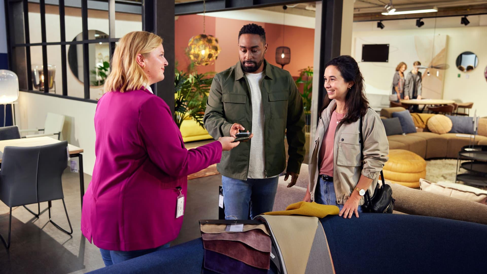 A couple buying furniture in store with a mPOS terminal