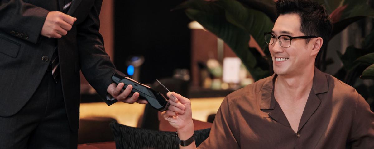 Man smiling while making a payment using an Adyen payment terminal