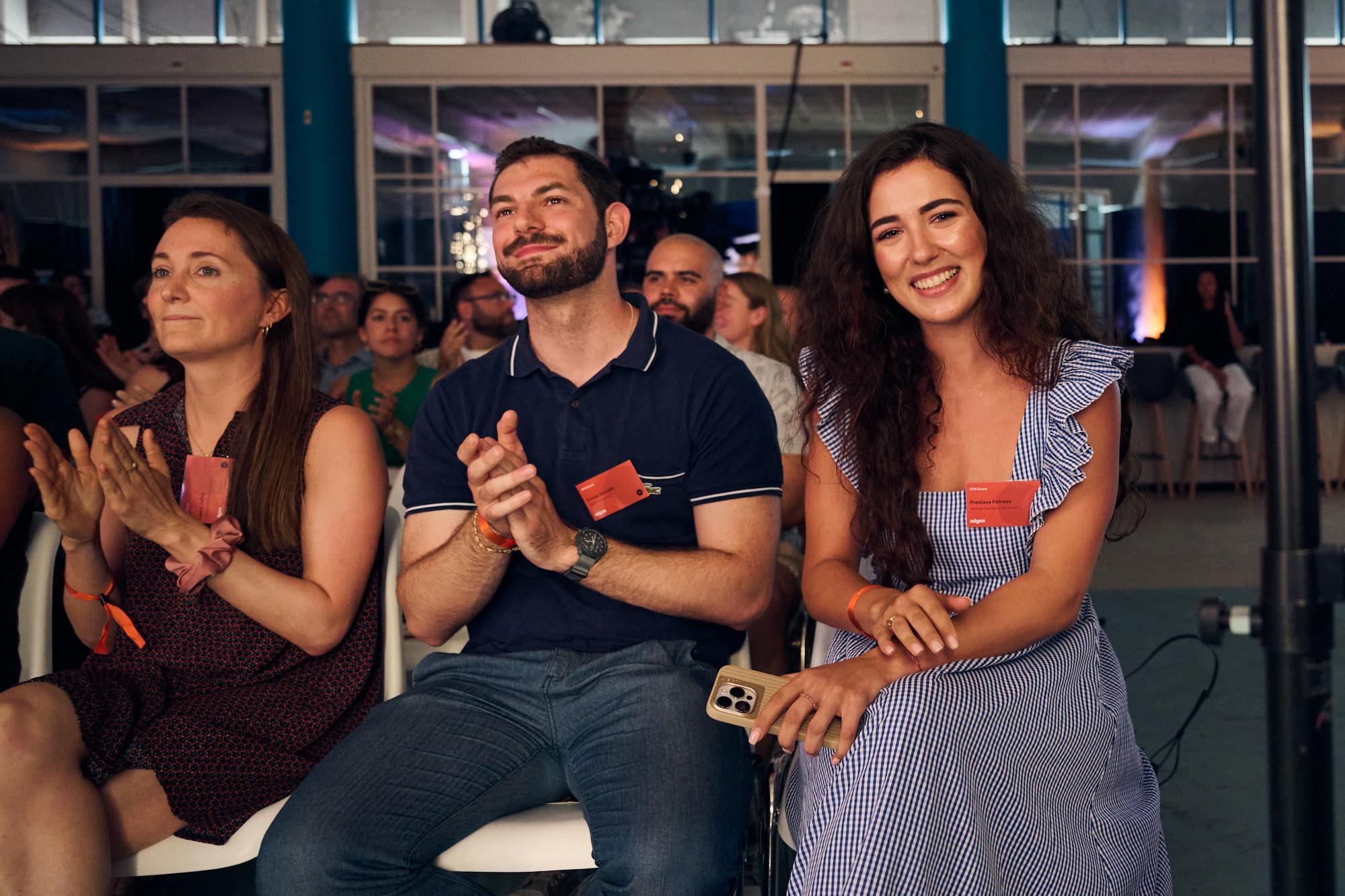 three people in a crowd clapping and laughing 