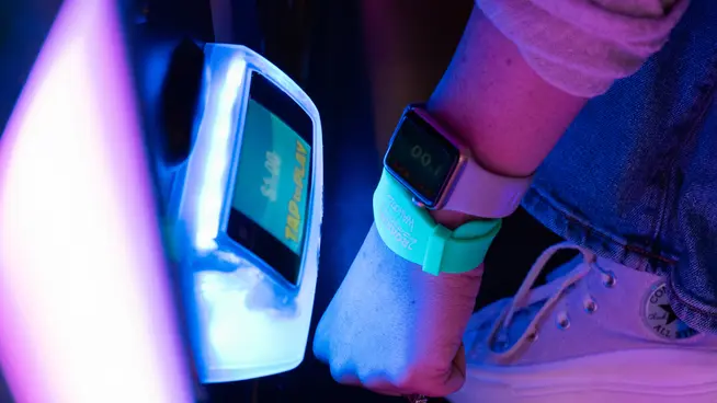 Person using an Adyen payment terminal with a wearable device.