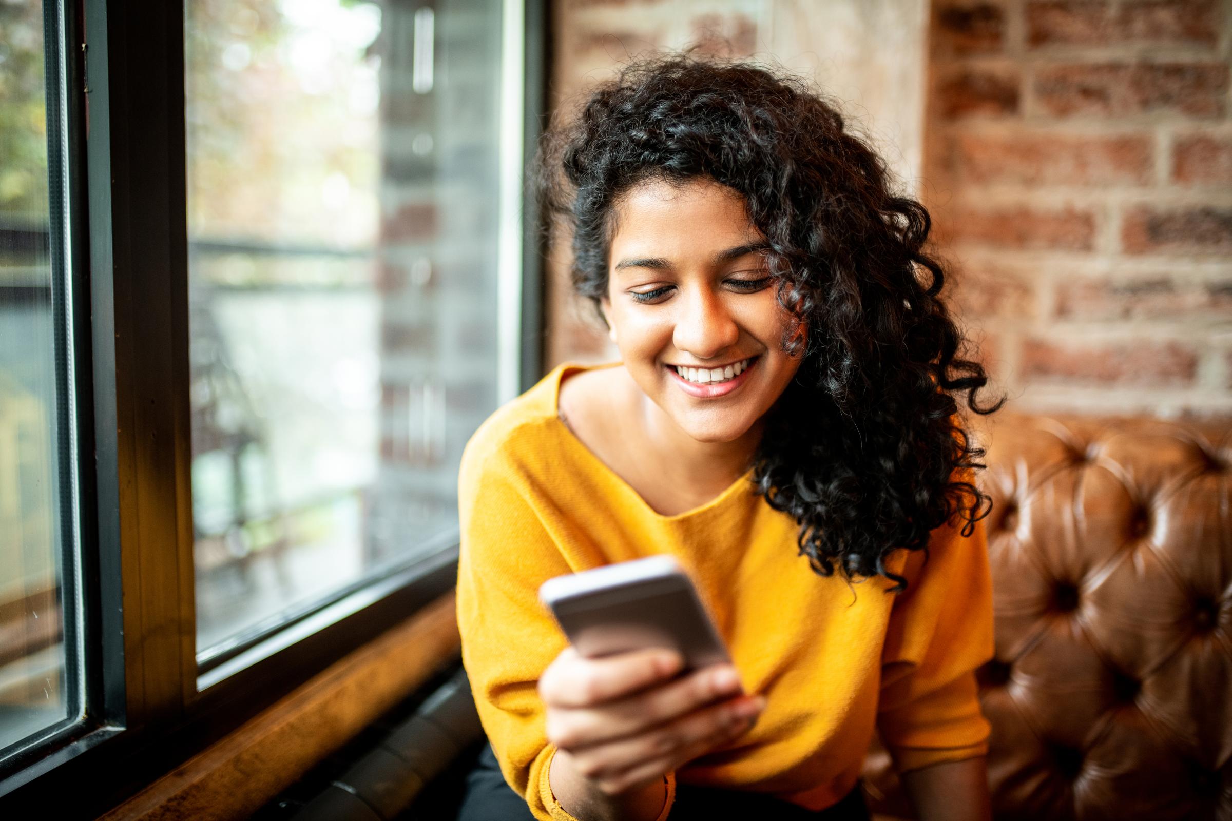Young Indian woman using mobile phone