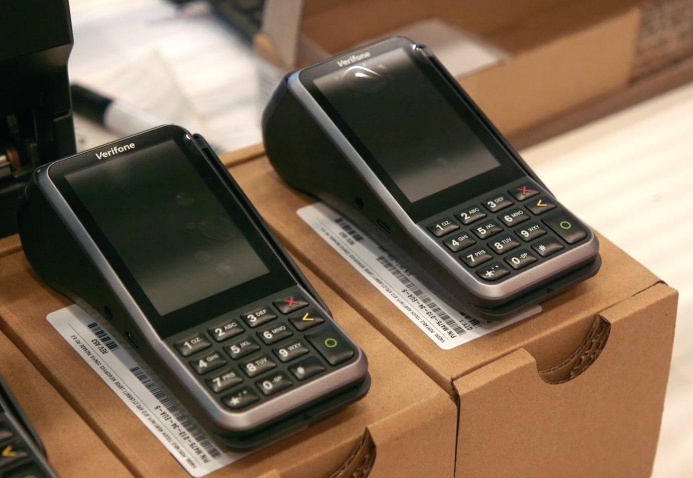 Two Verifone card payment terminals on a cardboard box.