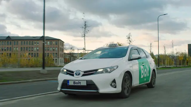 Veículo Toyota branco com marca Bolt a circular numa estrada