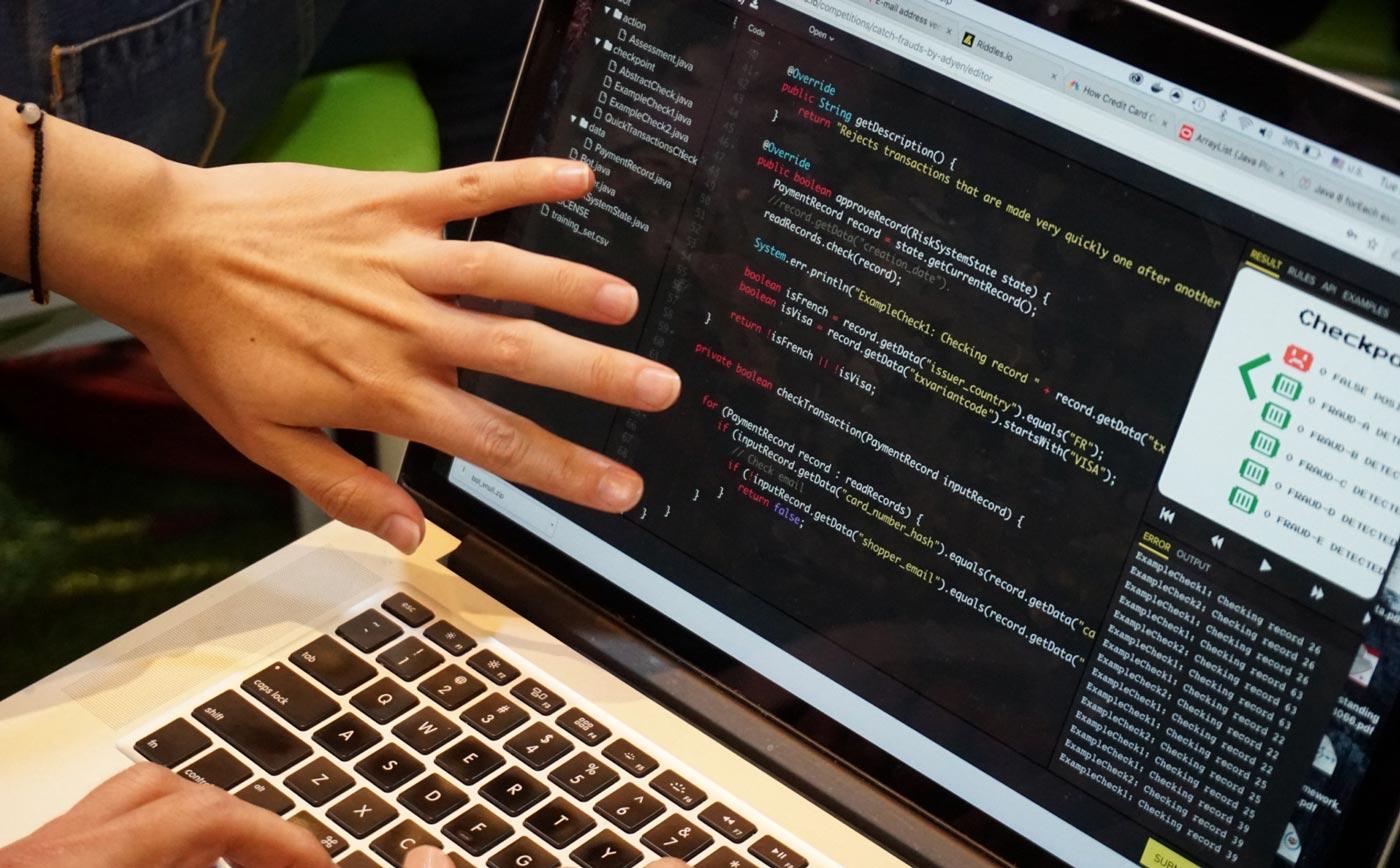 Pessoa codificando em um laptop com o produto Adyen Checkout na tela