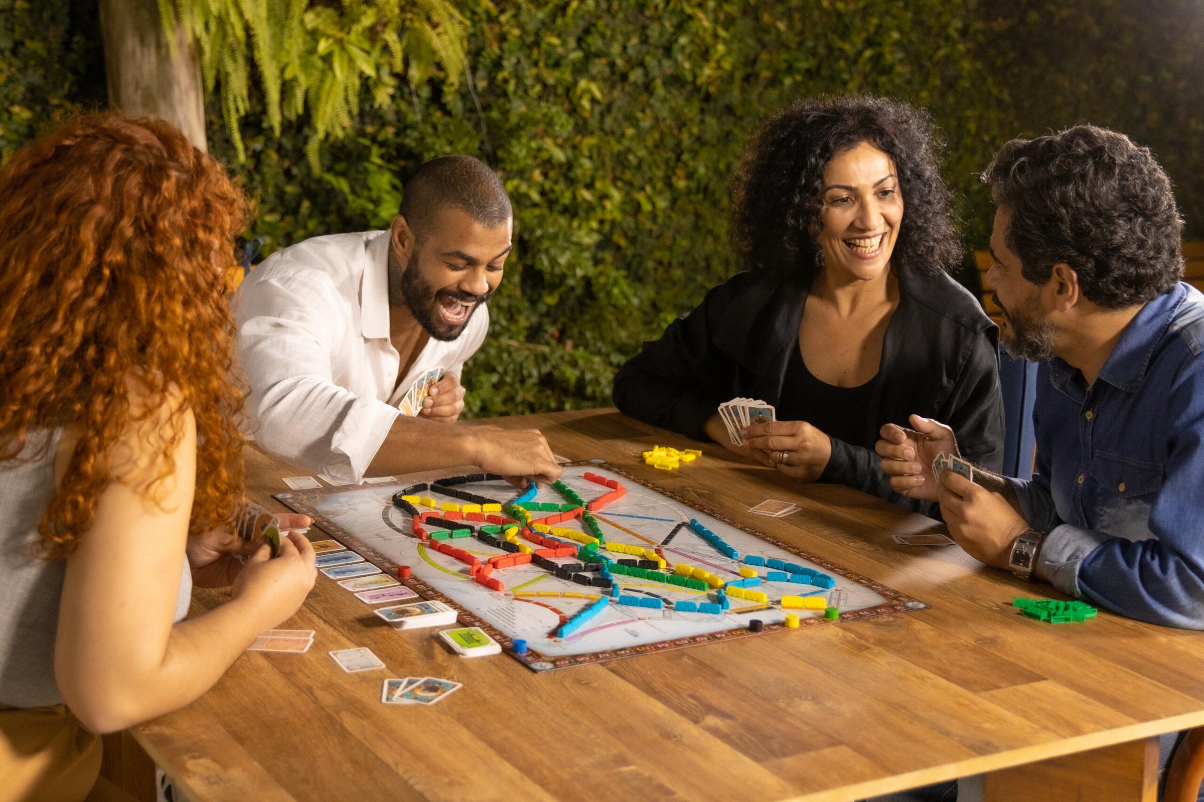 Um grupo de pessoas jogando jogos de tabuleiro em uma mesa
