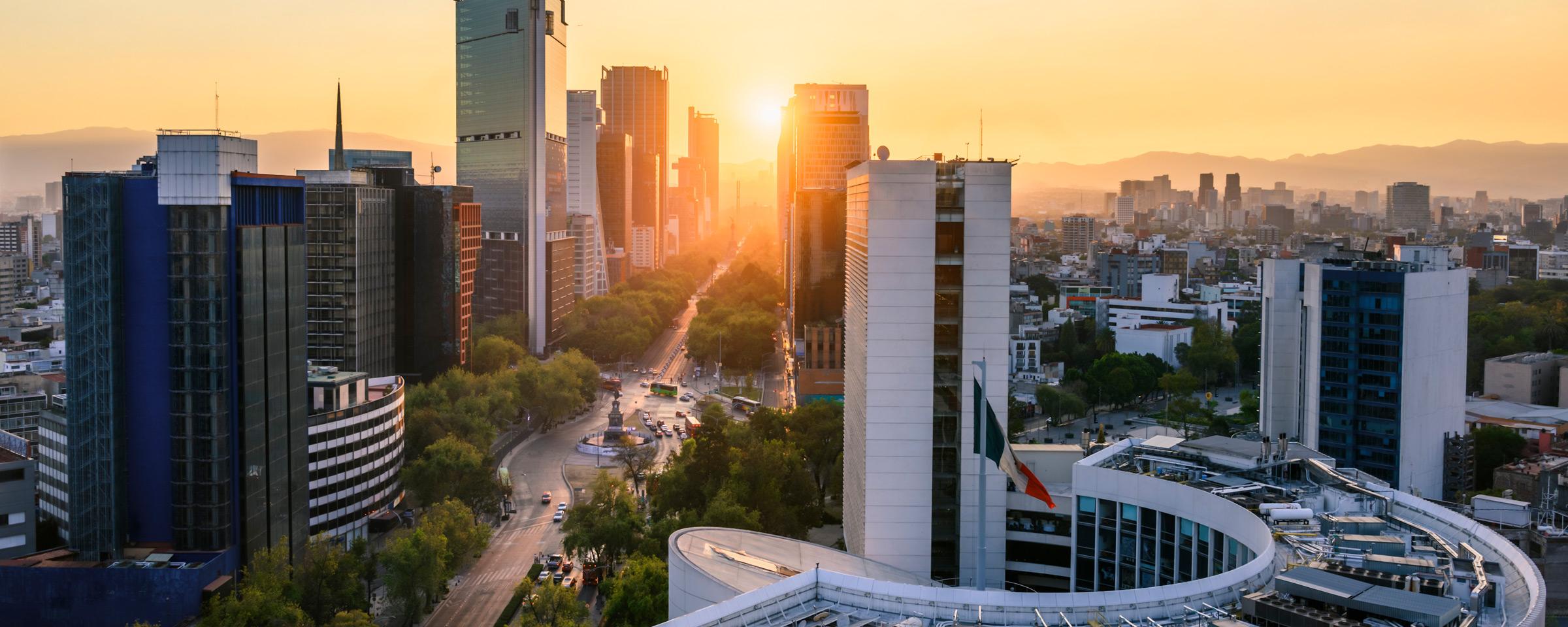 Vue du coucher du soleil sur un skyline urbain avec des bâtiments modernes.
