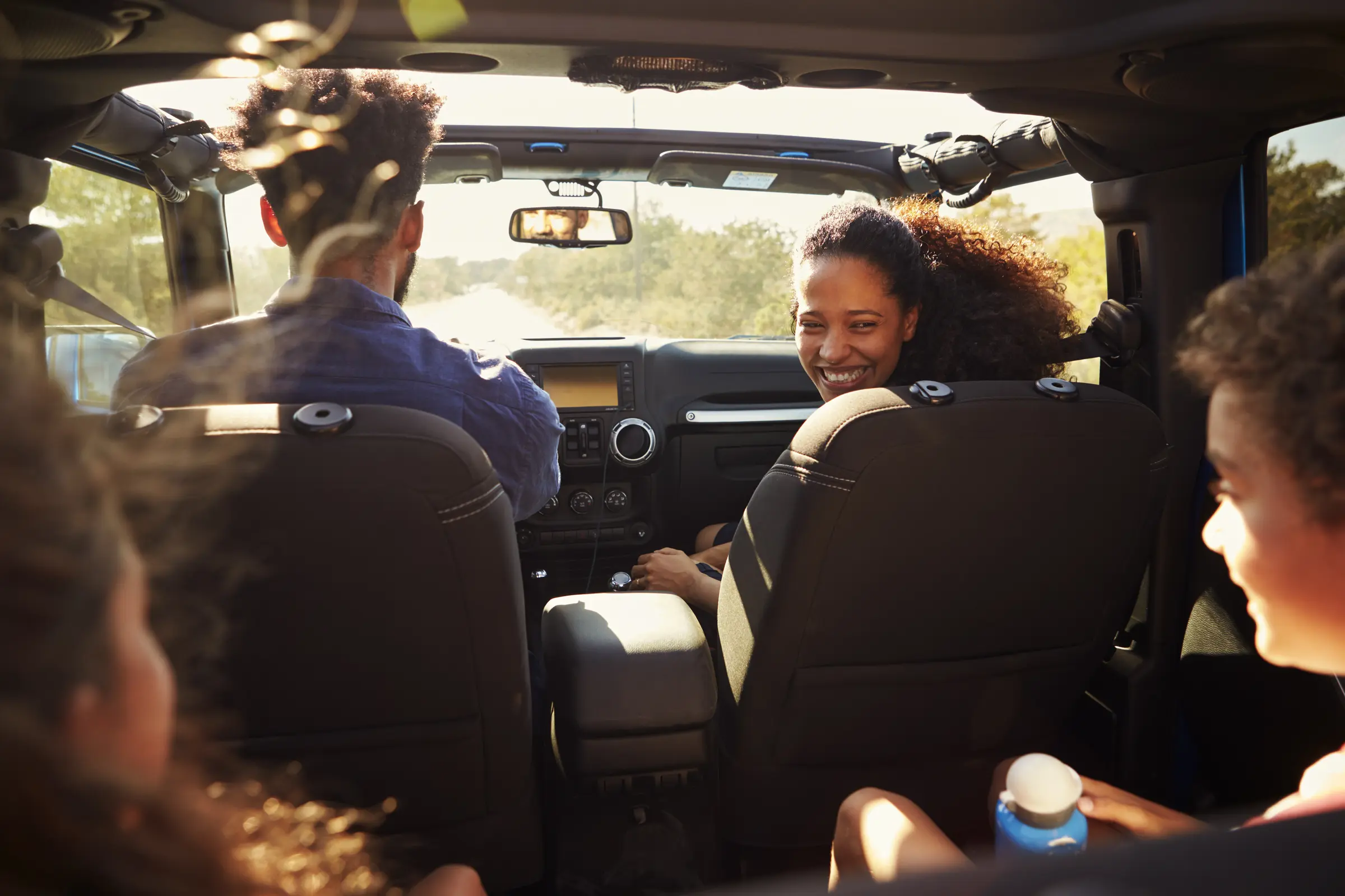 Family inside their car smiling