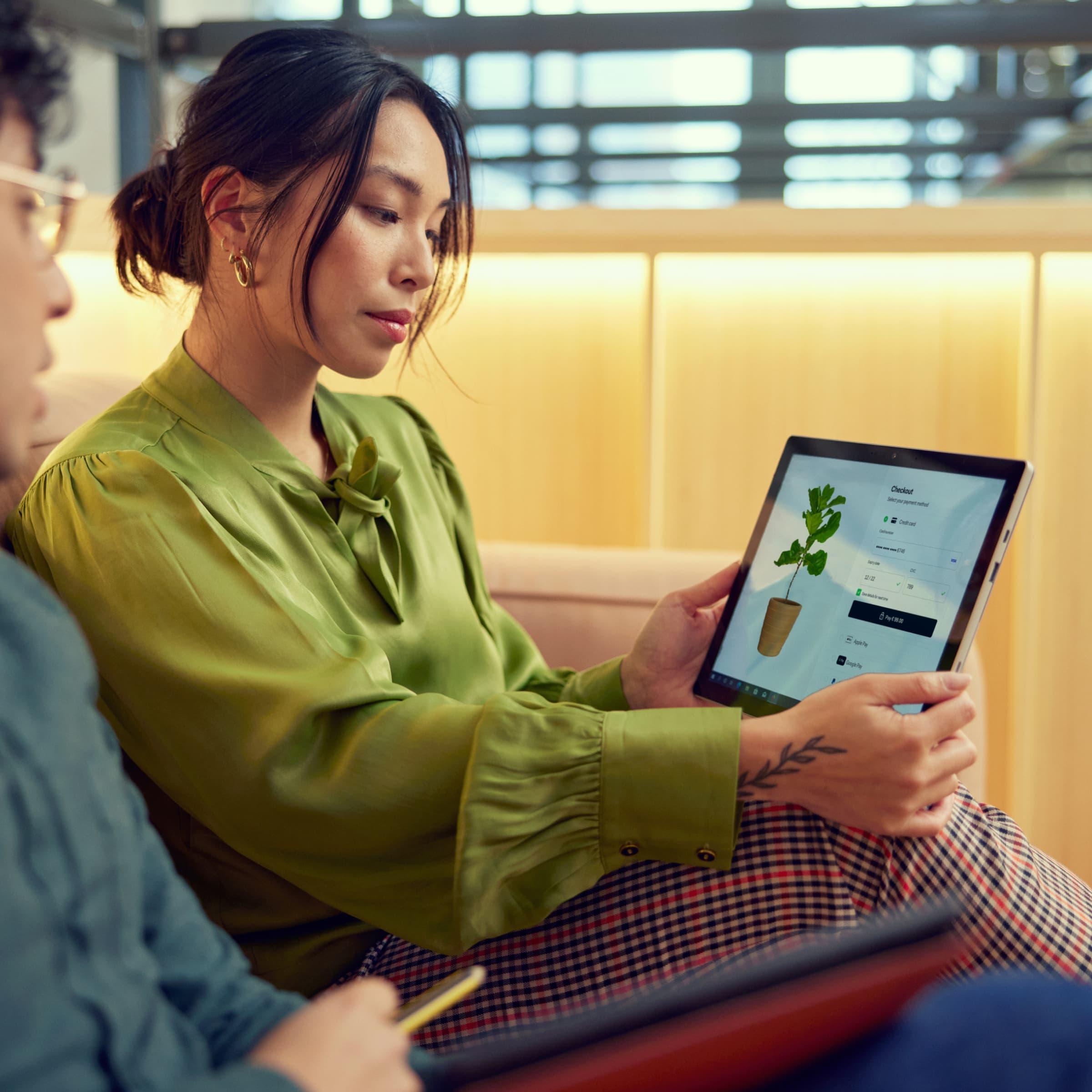 Two people reviewing a checkout interface on a tablet displaying Adyen's payment platform.