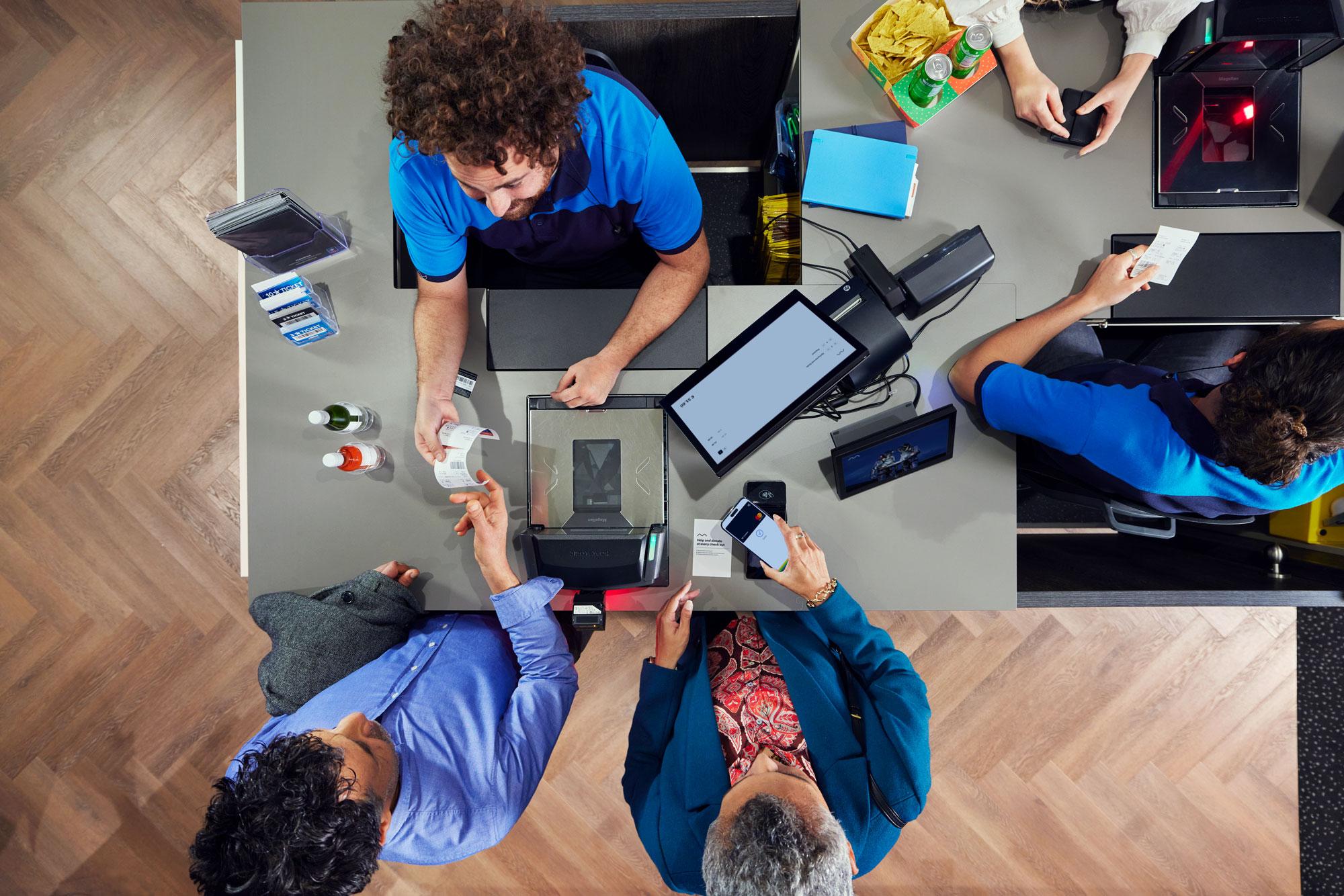 Cinema visitors paying for tickets by tapping a smartphone at Adyen's S1F2 terminal.