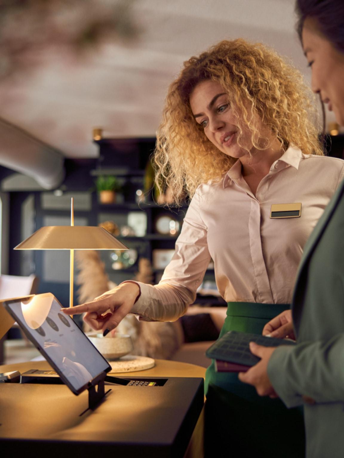 Garçonete ajudando um cliente com pagamento em um tablet em um restaurante