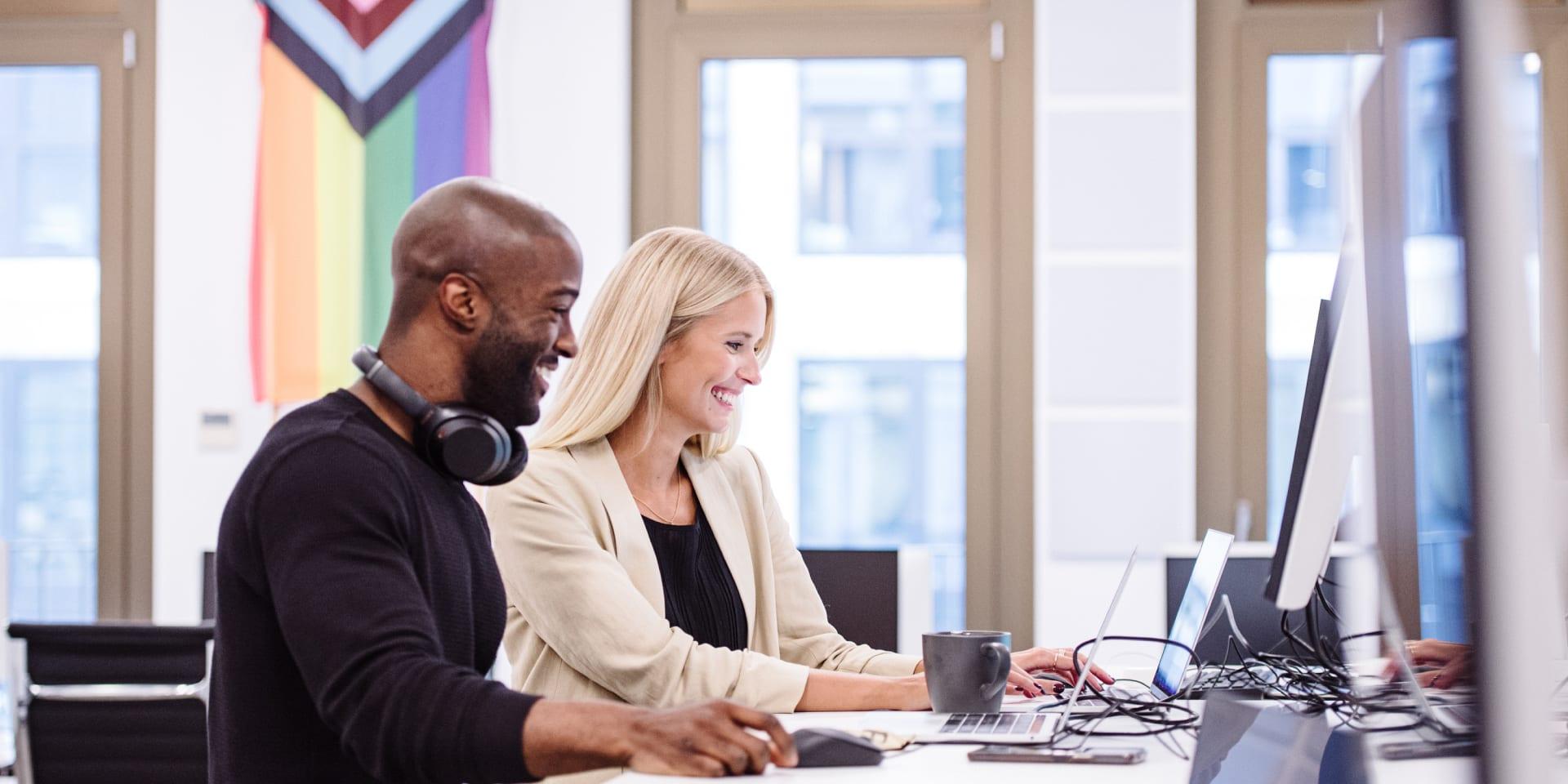 Zwei Mitarbeitende von Adyen Deutschland sitzen an einem Tisch im Büro