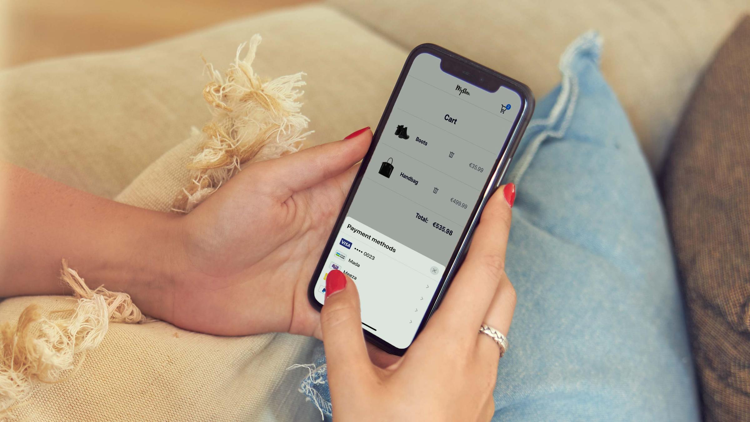 Person using smartphone to view shopping cart and payment methods.