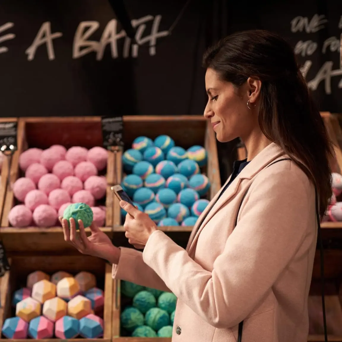 Woman scanning a QR code on a bath bomb at a store.