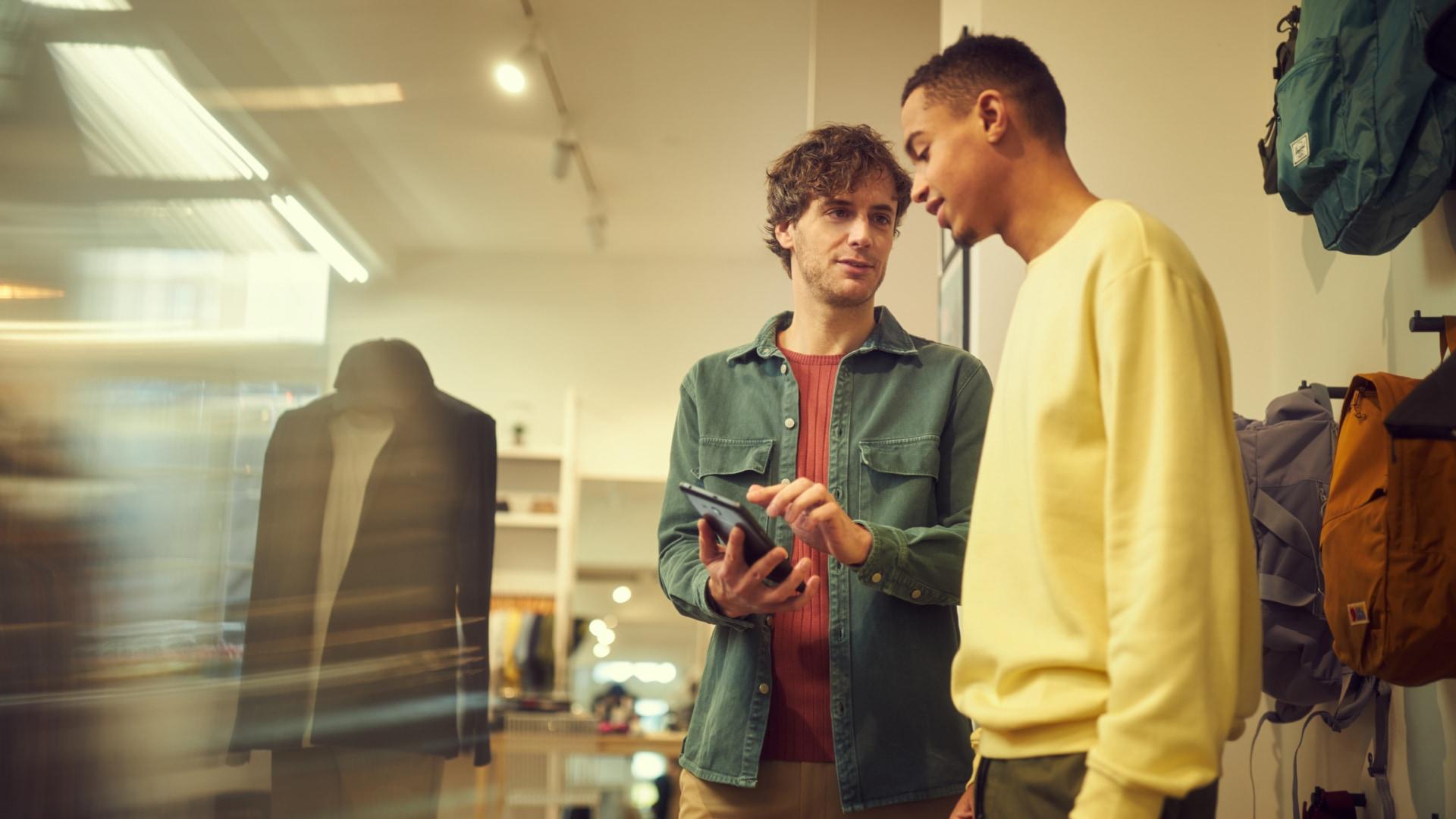 Two people interacting with a payment device in a retail store.